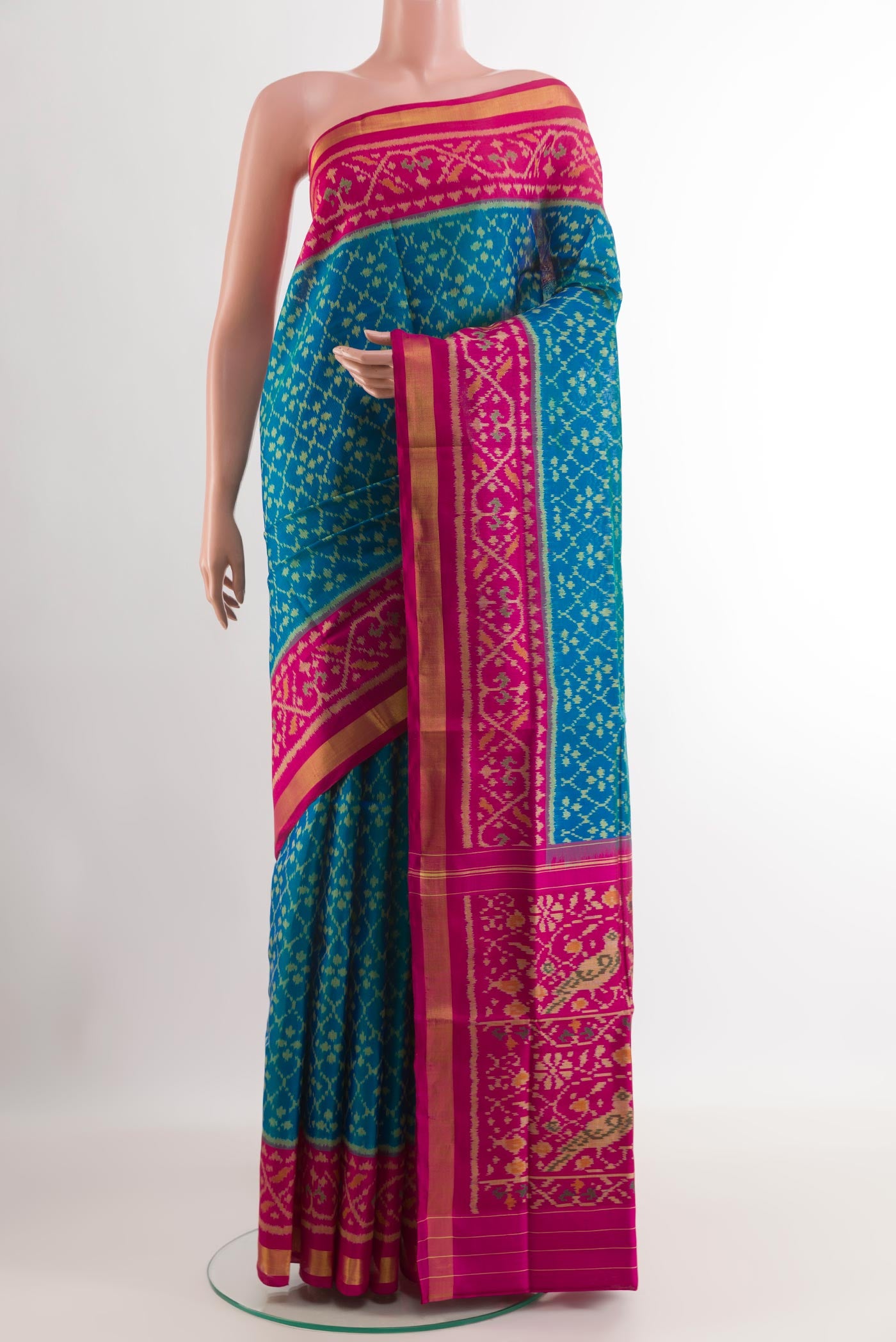 Blue Rajkot Patola Silk Saree with Ikat design on the body and Zari Border.  displayed on a mannequin