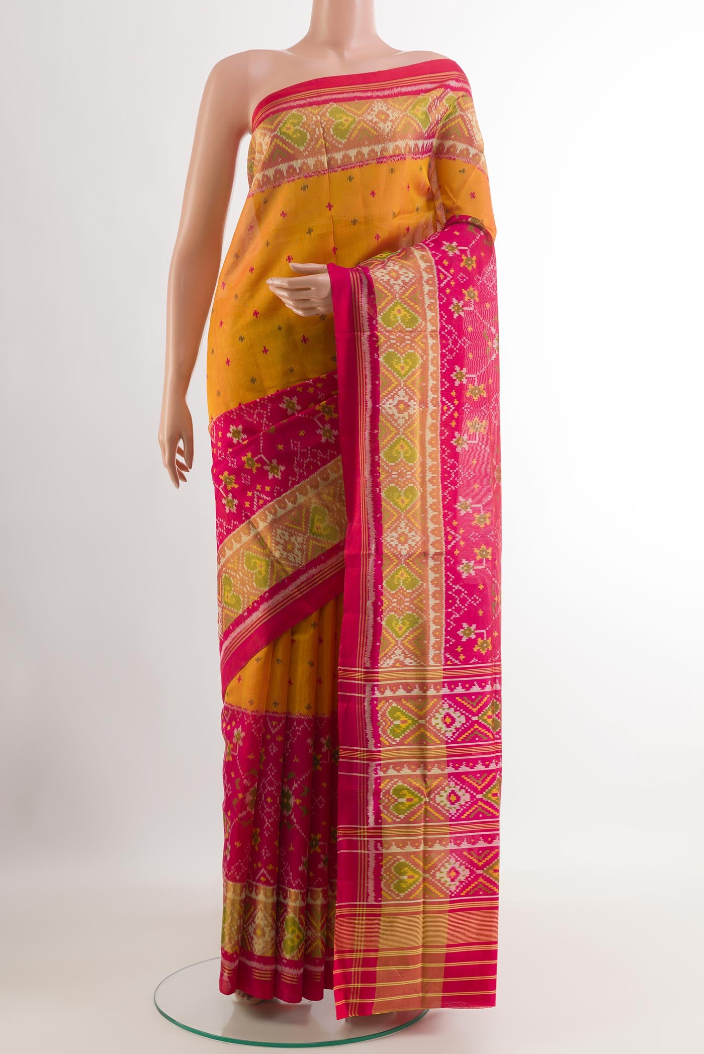 Yellow Rajkot Patola Silk Saree with Ikat design on the body and Zari Border.  displayed on a mannequin