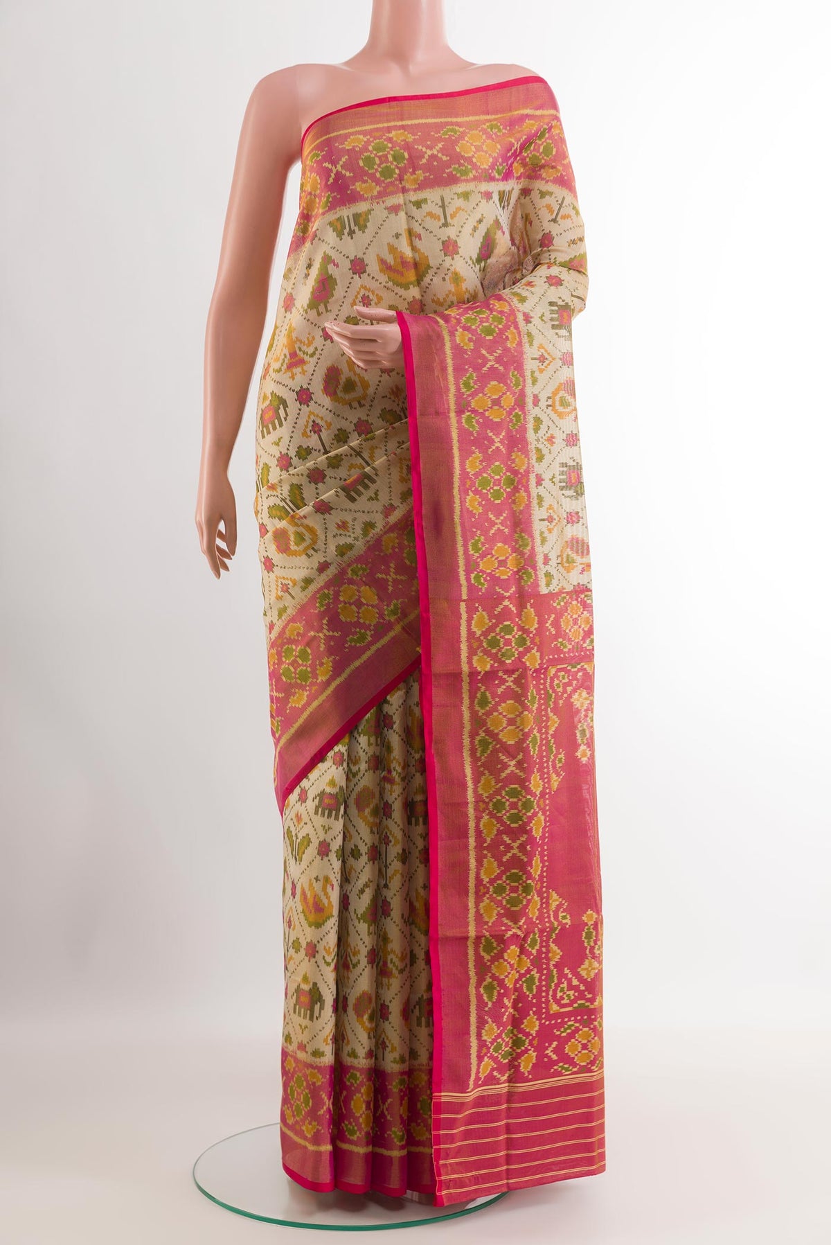 Cream Rajkot Patola Silk Saree with Ikat design on the body and Zari Border.  displayed on a mannequin