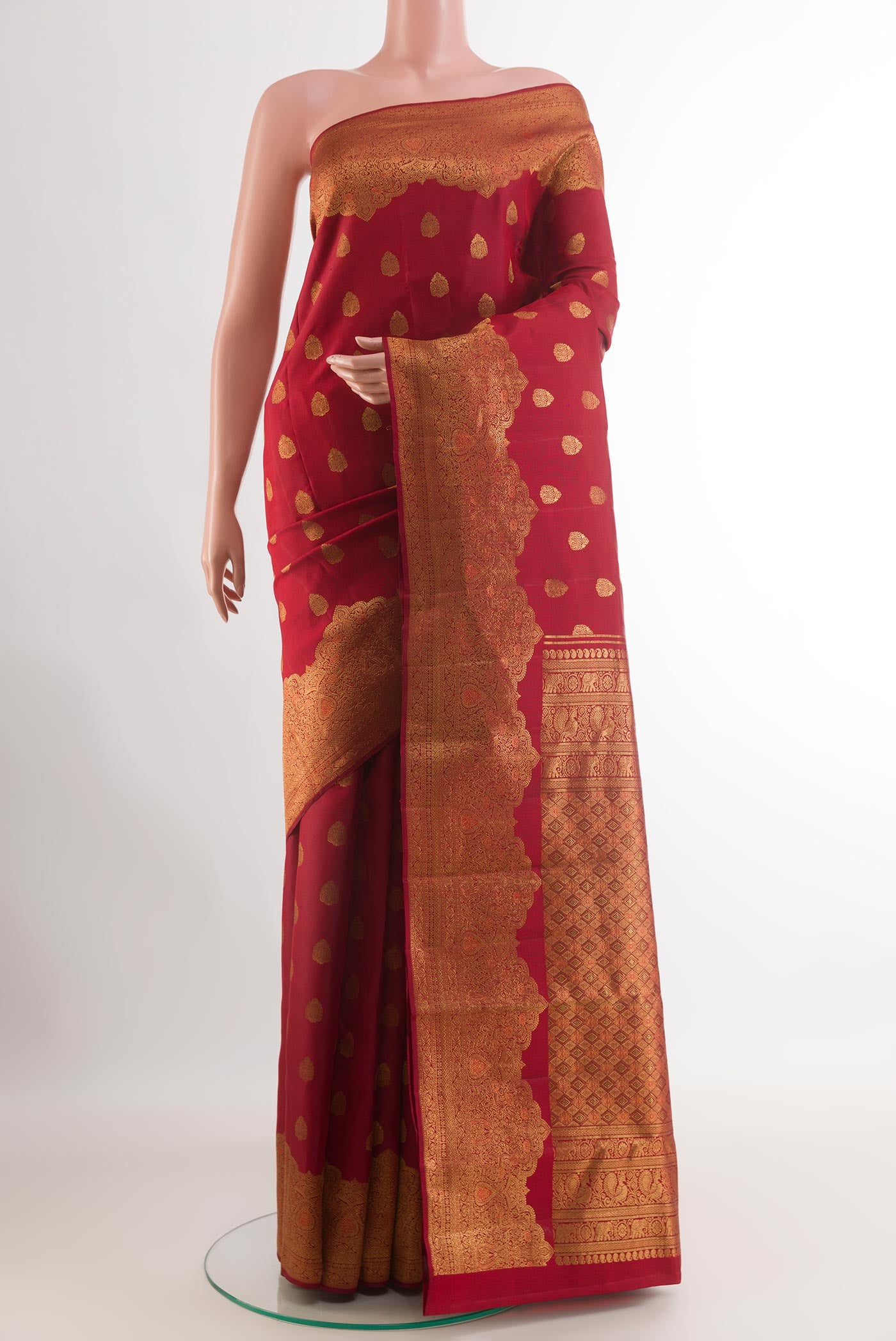 Maroon Kanchipuram Silk Saree with Zari Butta on the body and Zari Border.  displayed on a mannequin