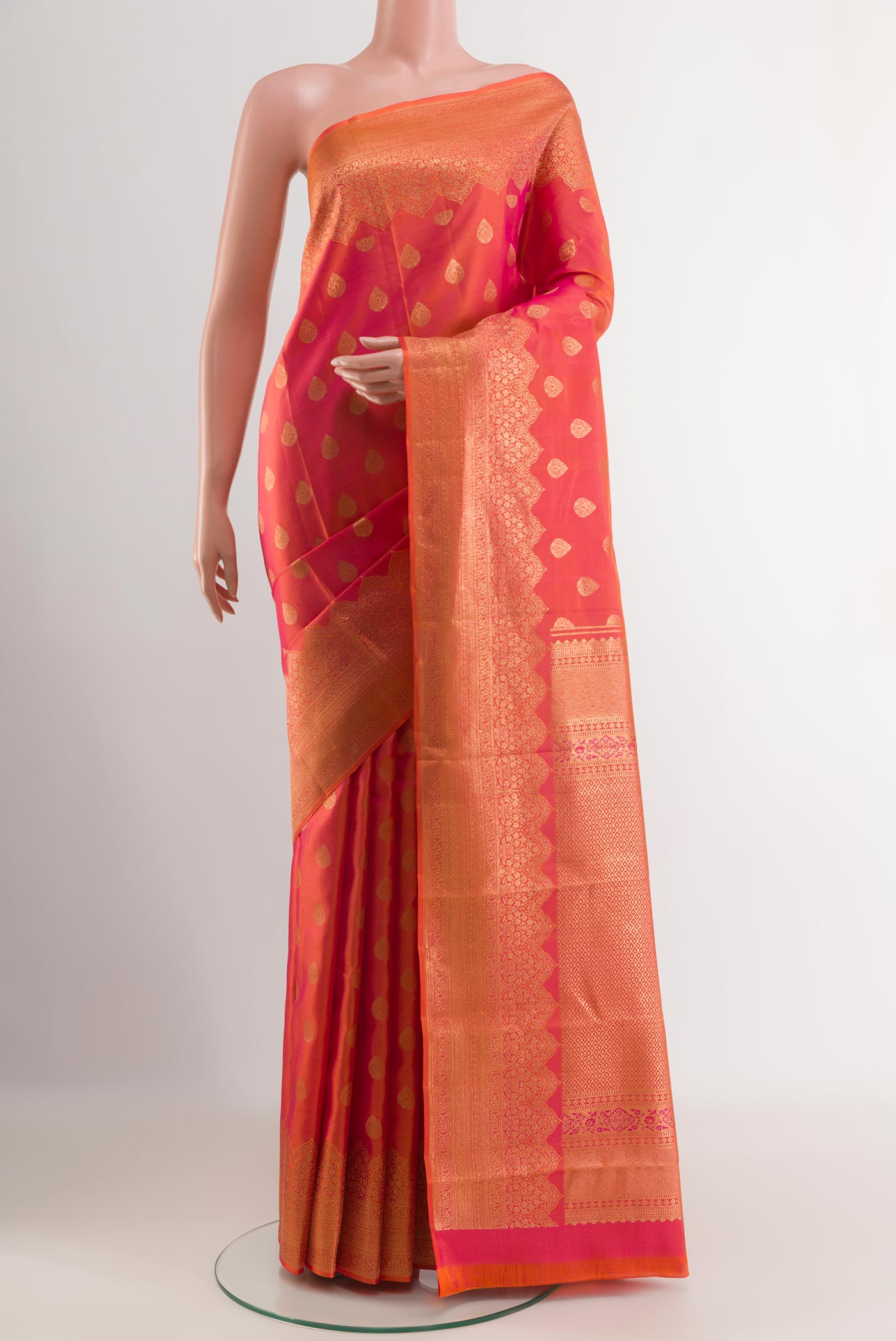 Peach Kanchipuram Silk Saree with Zari Butta on the body and Zari Border.  displayed on a mannequin
