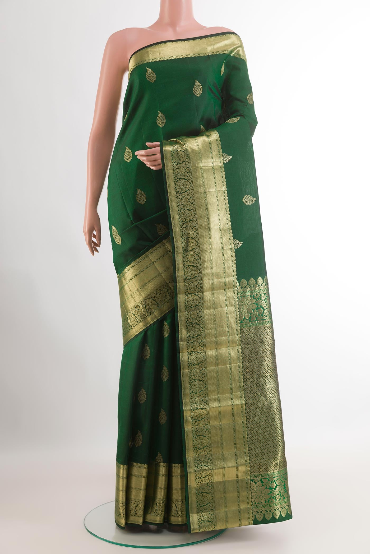 Green Kanjivaram Silk Saree with Zari Butta on the body and Zari Border.  displayed on a mannequin