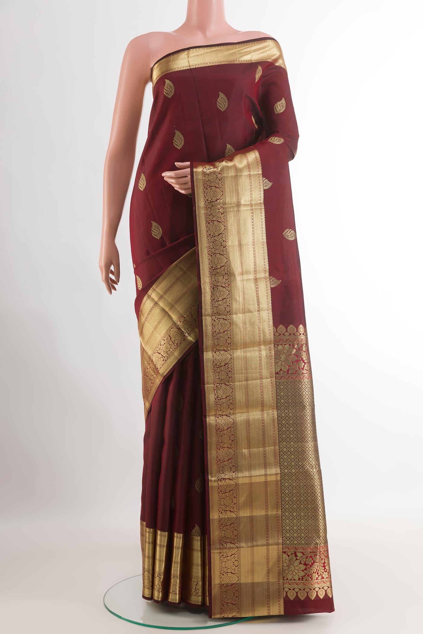 Maroon Kanjivaram Silk Saree with Zari Butta on the body and Zari Border.  displayed on a mannequin