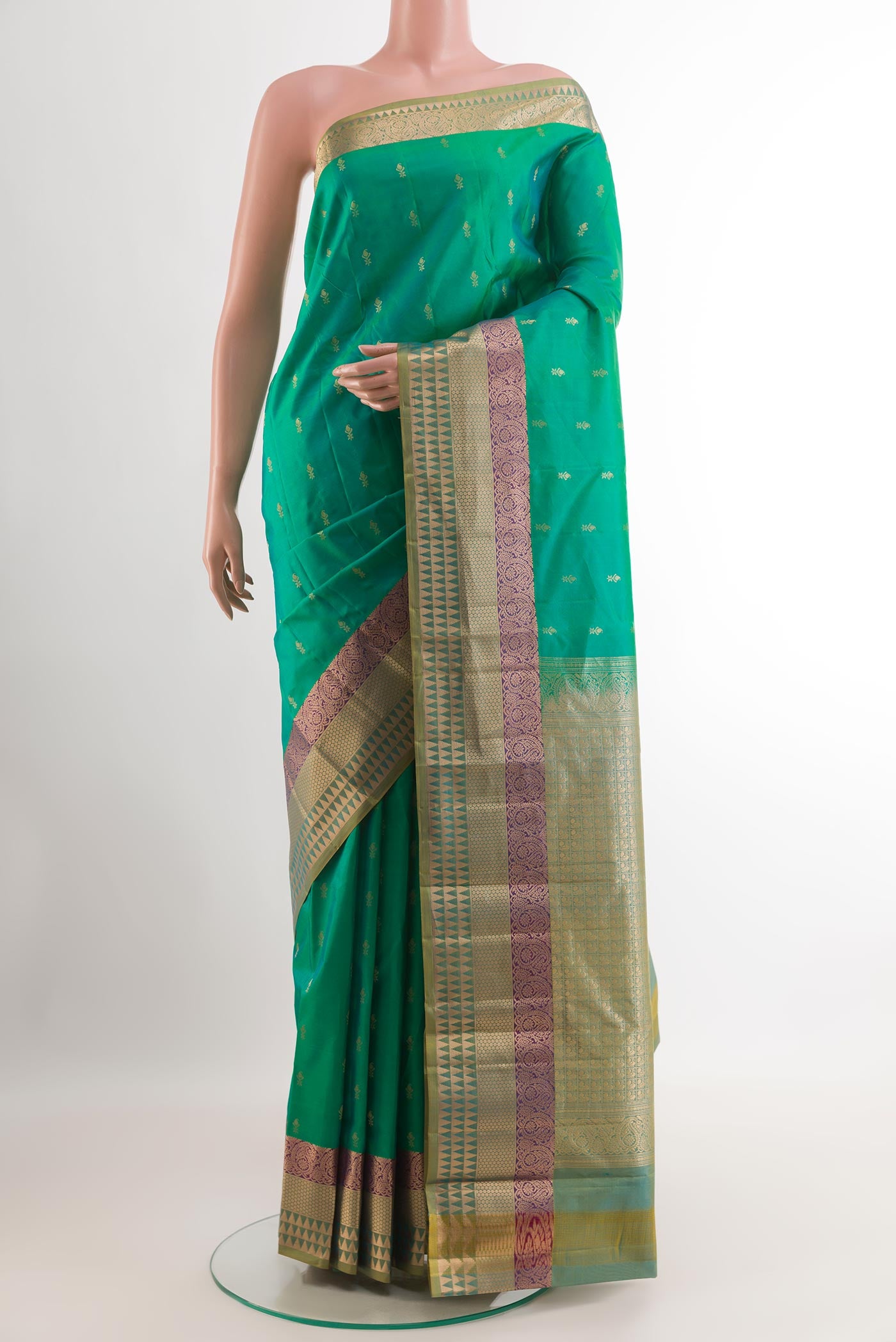Green Kanjivaram Silk Saree with Zari Butta on the body and Zari Border.  displayed on a mannequin