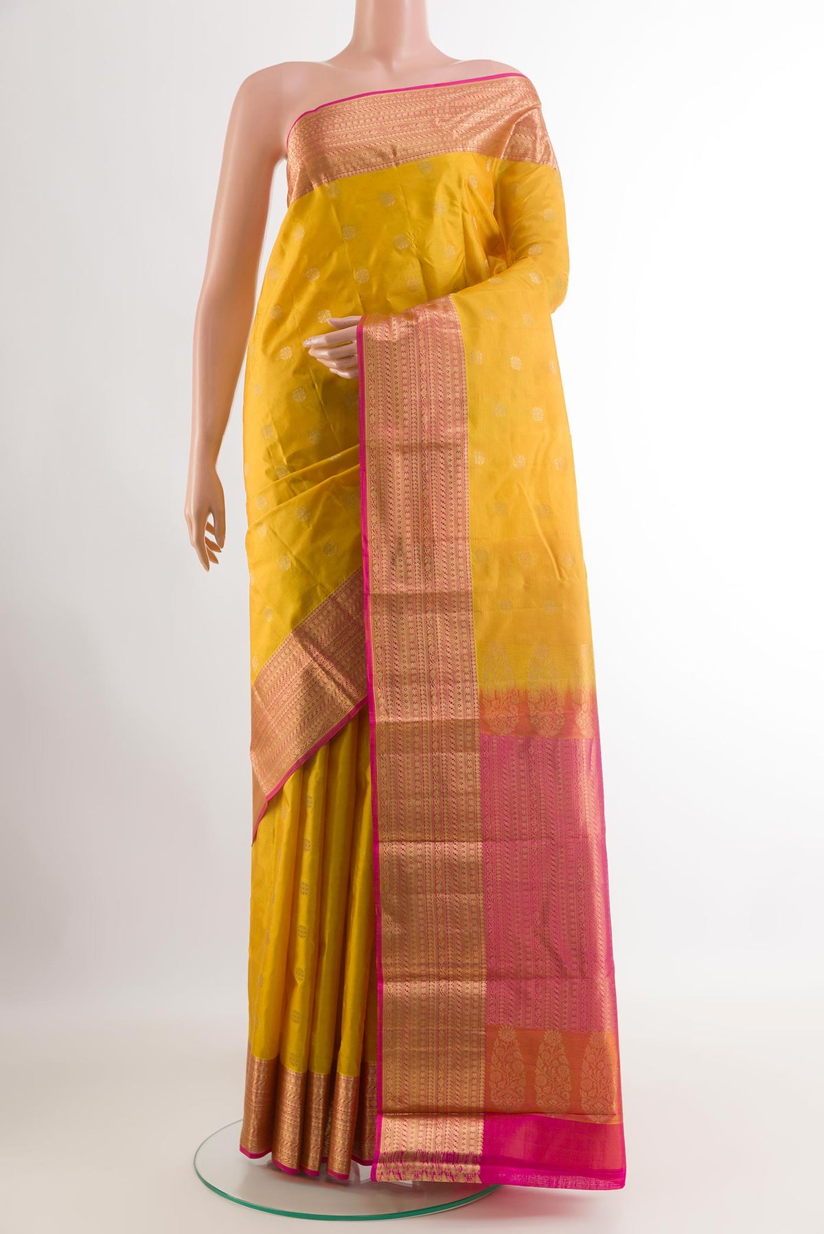 Yellow Kanjivaram Silk Saree with Zari Butta on the body and Zari Border.  displayed on a mannequin