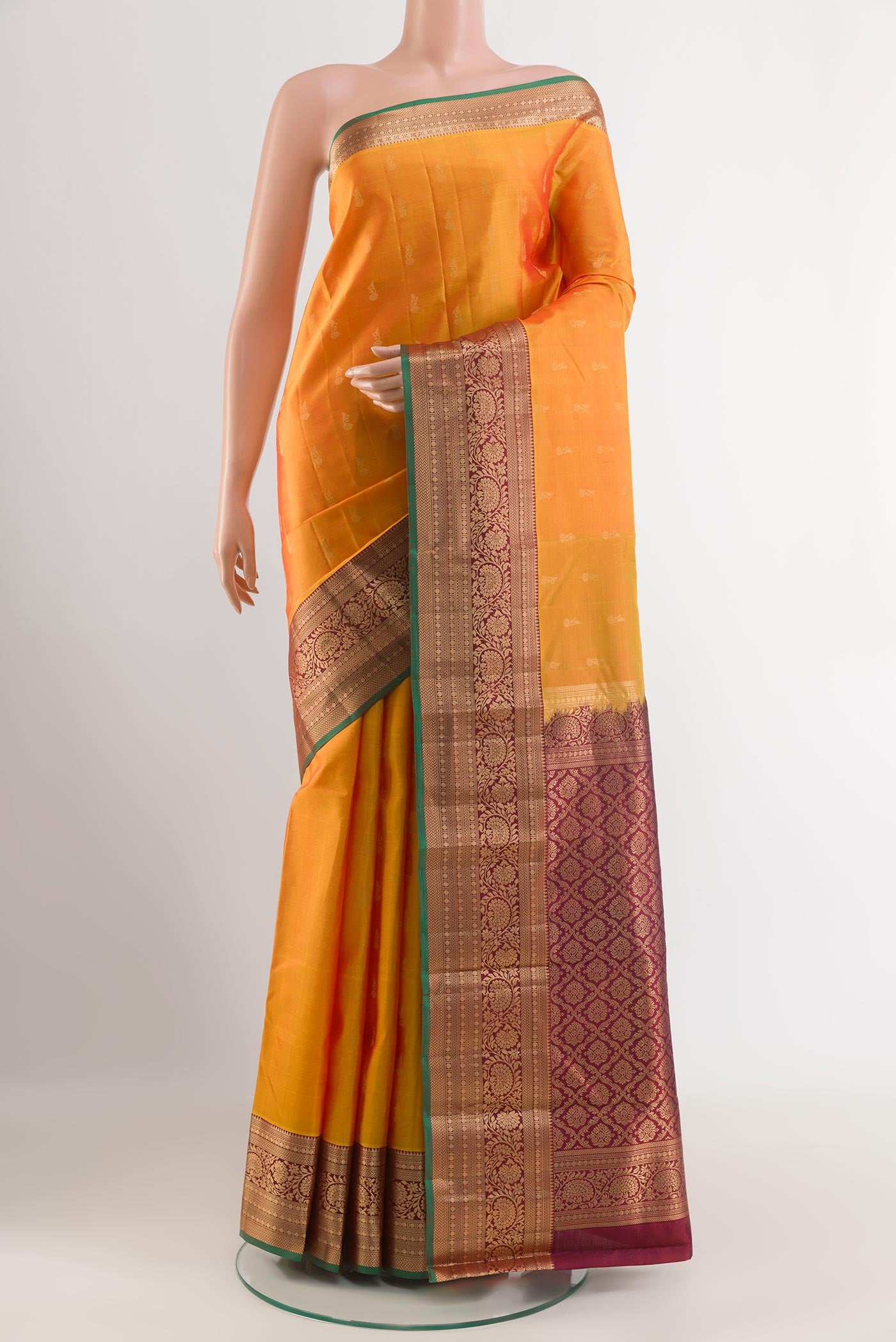 Orange Kanjivaram Silk Saree with Zari Butta on the body and Zari Border.  displayed on a mannequin