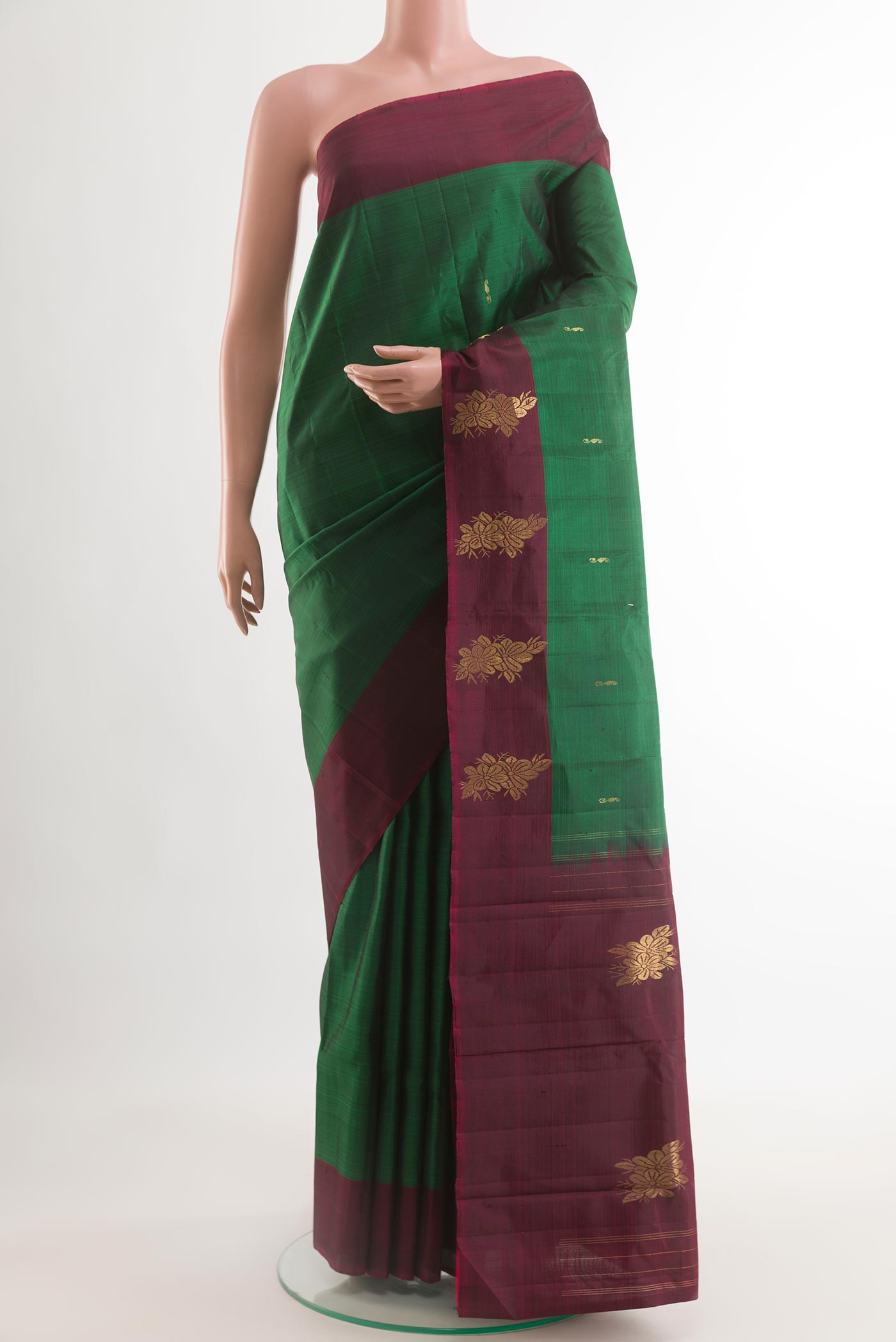 Bottle Green Kanchipuram Silk Saree with Zari Butta on the body and Zari Border.  displayed on a mannequin