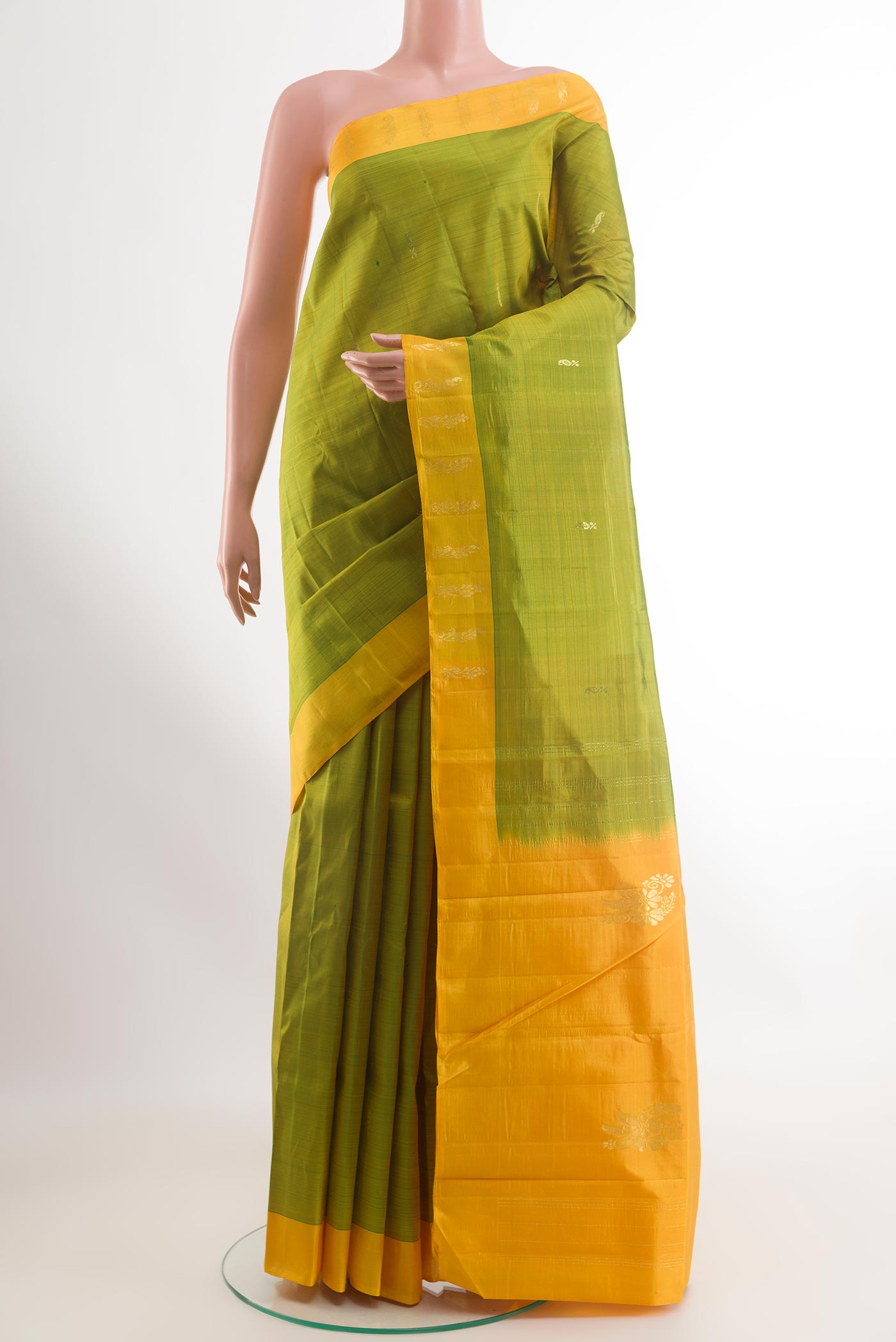 Green Kanchipuram Silk Saree with Zari Butta on the body and Zari Border.  displayed on a mannequin