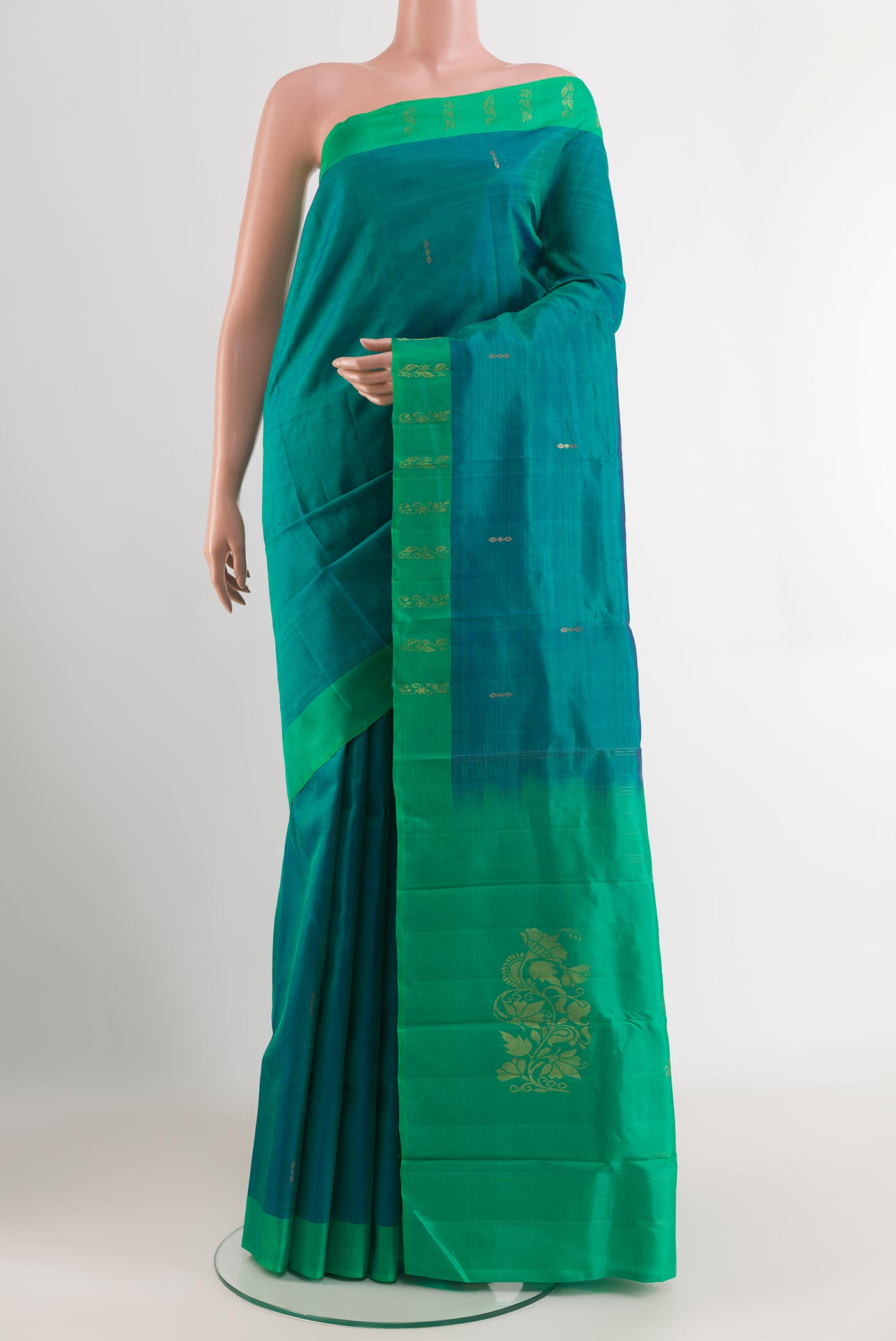 Peacock Blue Kanchipuram Silk Saree with Zari Butta on the body and Zari Border.  displayed on a mannequin