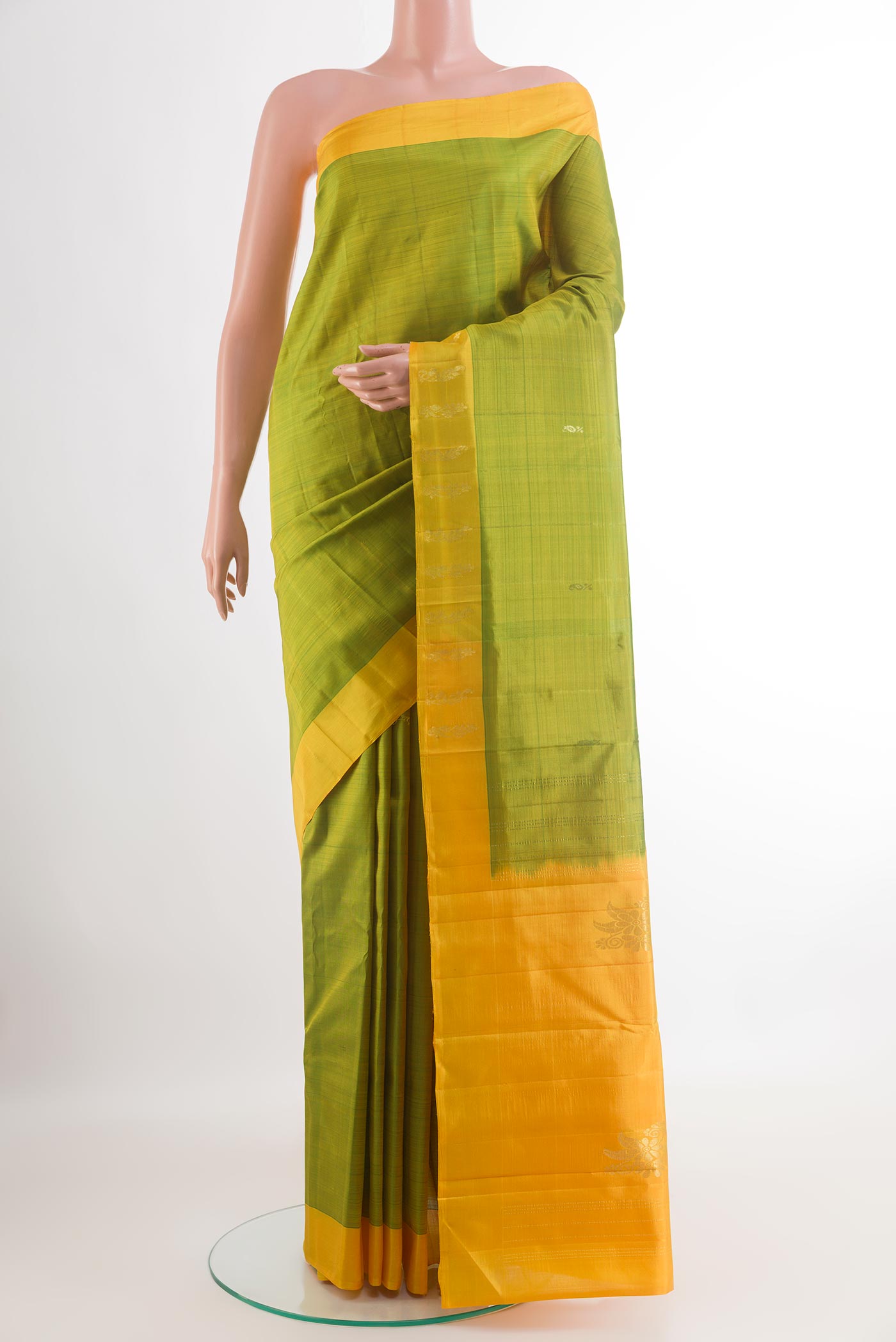 Green Kanchipuram Silk Saree with Zari Butta on the body and Zari Border.  displayed on a mannequin