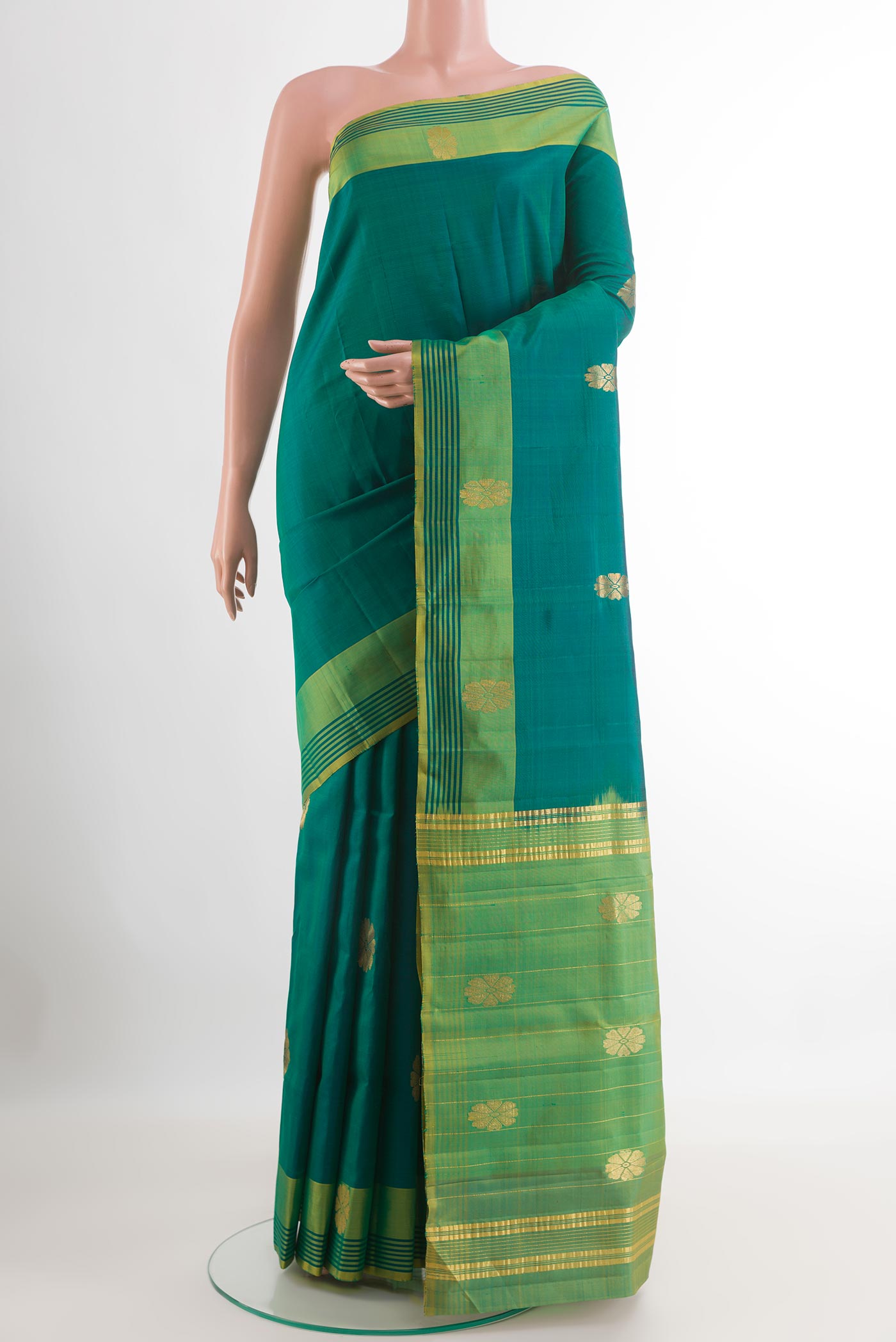 Green Kanchipuram Silk Saree with Zari Butta on the body and Zari Border.  displayed on a mannequin