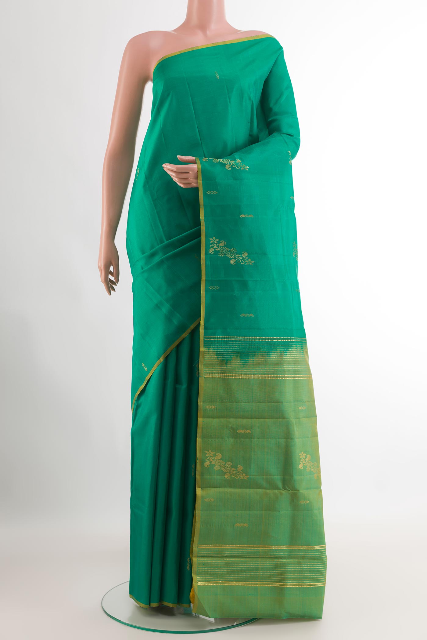 Green Kanchipuram Silk Saree with Zari Butta on the body and Zari Border.  displayed on a mannequin