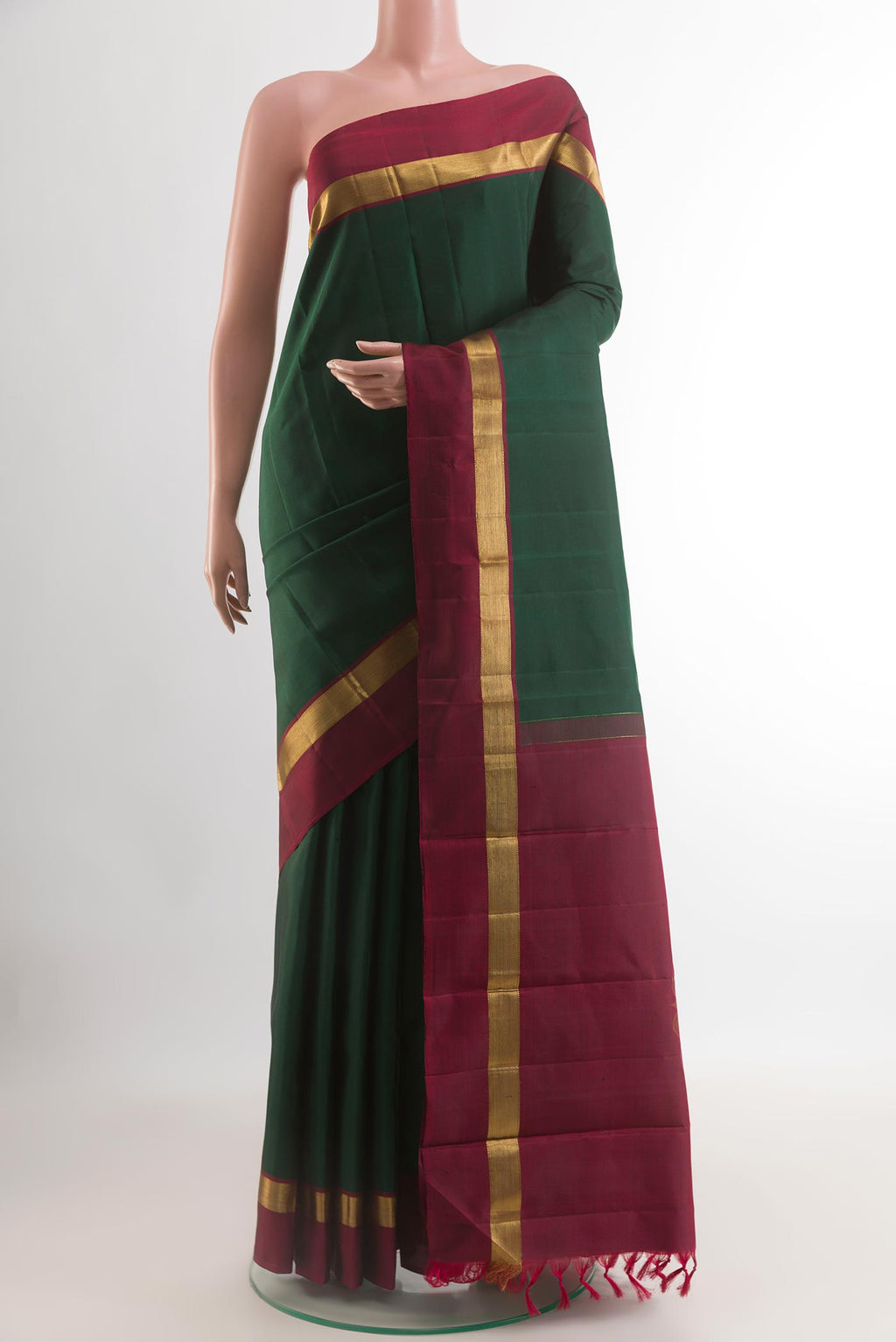 Bottle Green Kanchipuram Silk Saree with Plain Body and Zari Border.  displayed on a mannequin
