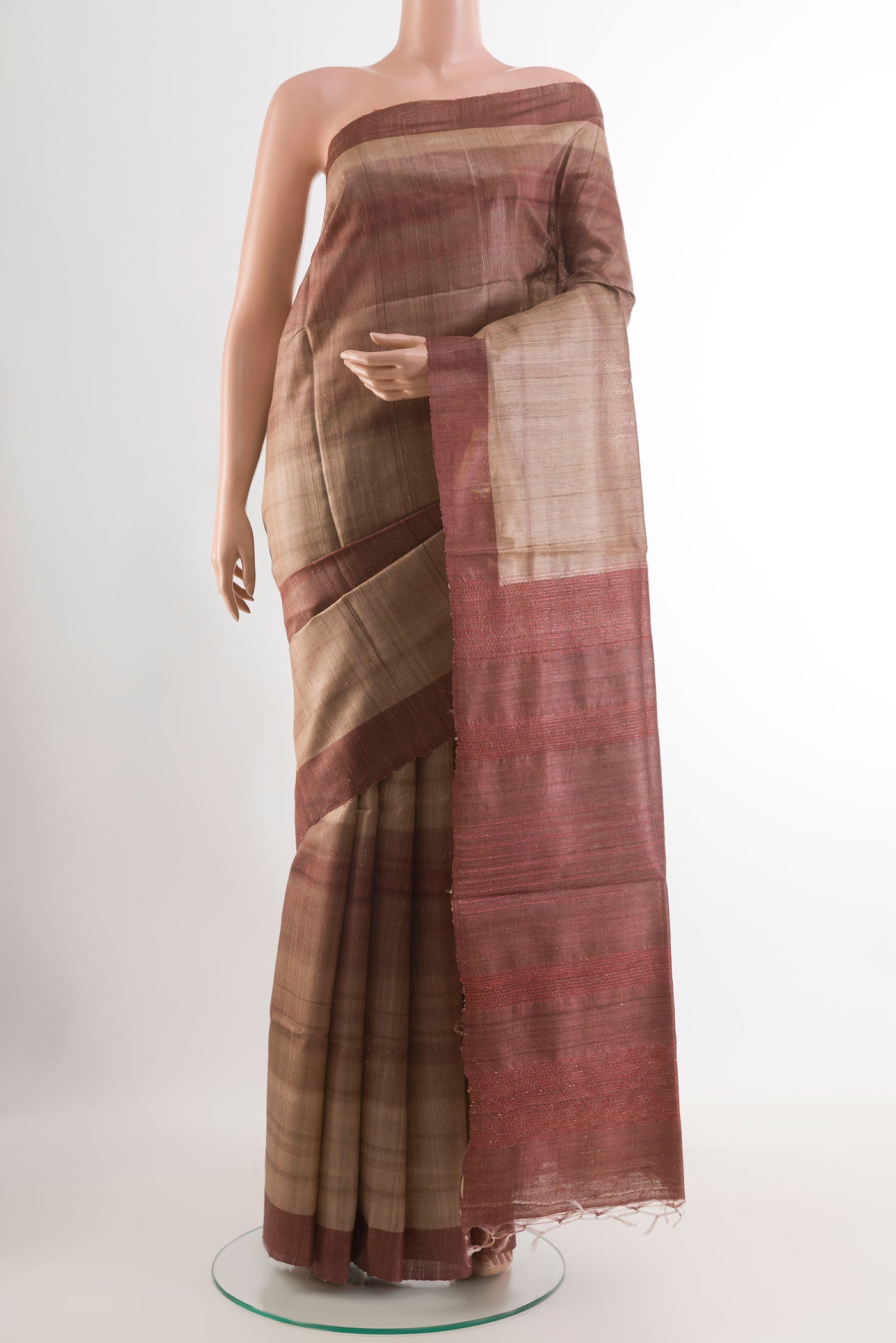 Beige Tussar Saree with Printed design on the body and Zari Border.  displayed on a mannequin