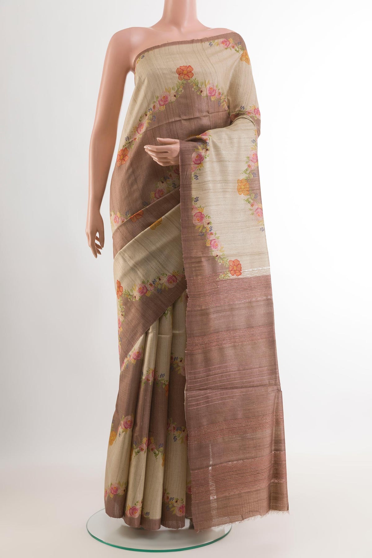Beige Tussar Saree with Printed design on the body and Zari Border.  displayed on a mannequin