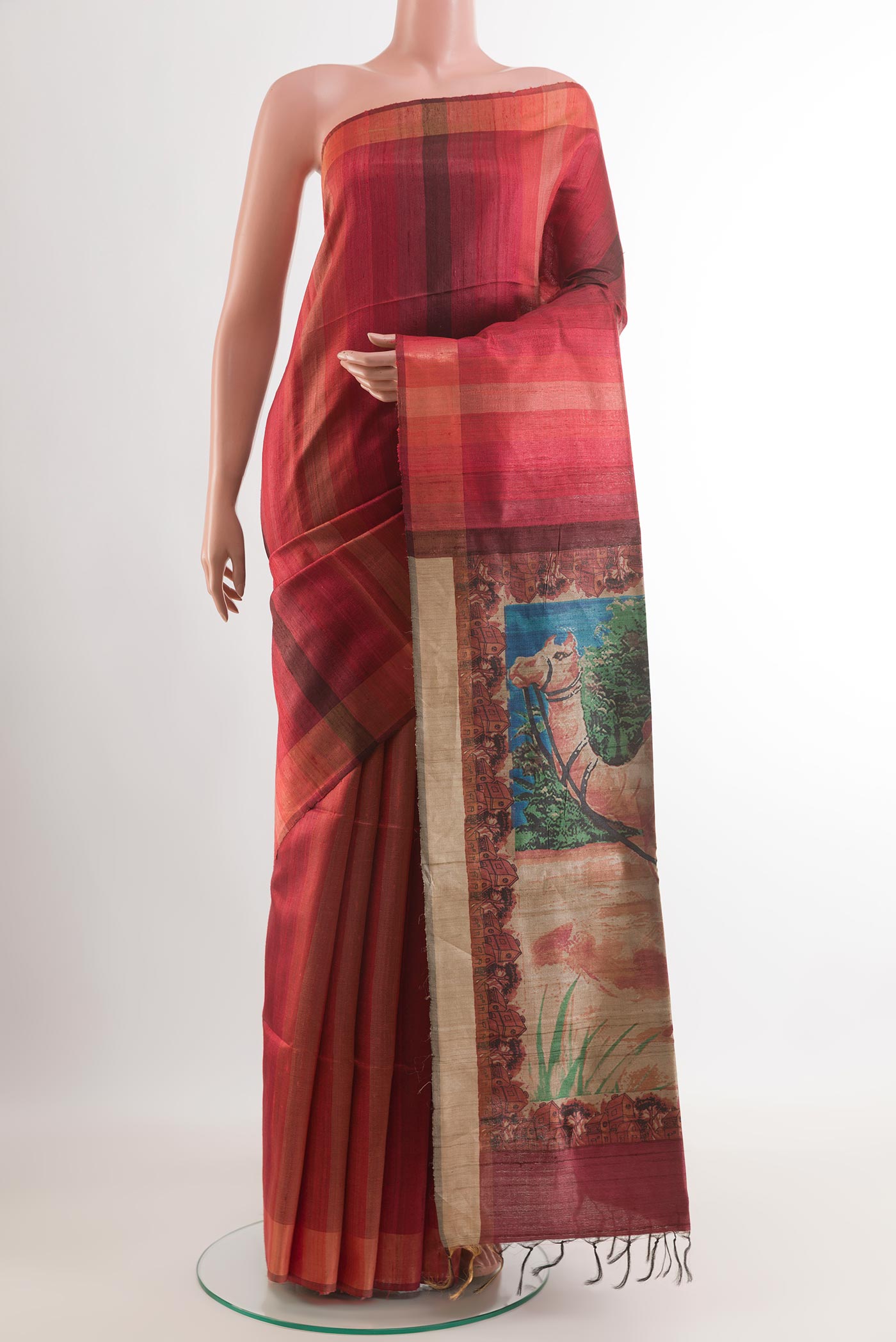 Red Tussar Saree with Printed design on the body and Zari Border.  displayed on a mannequin