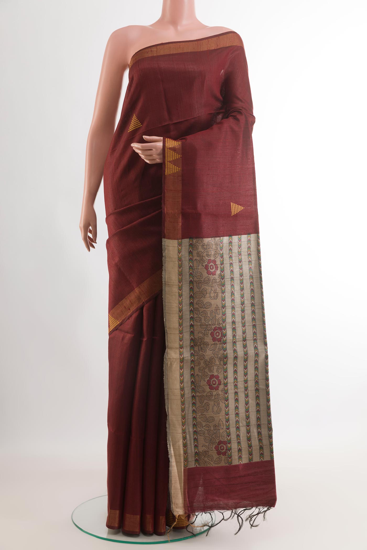 Maroon Tussar Saree with Printed design on the body and Zari Border.  displayed on a mannequin