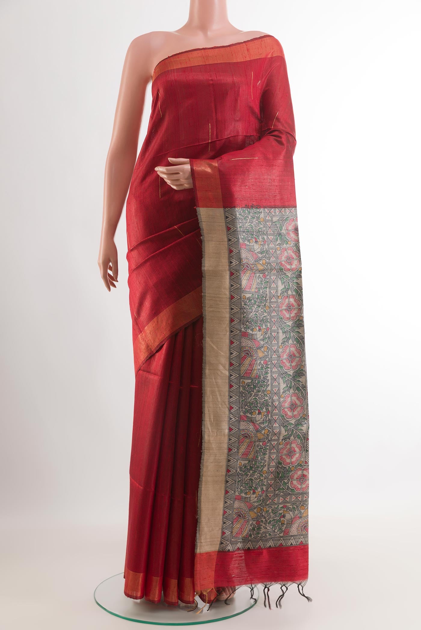 Red Tussar Saree with Printed design on the body and Zari Border.  displayed on a mannequin