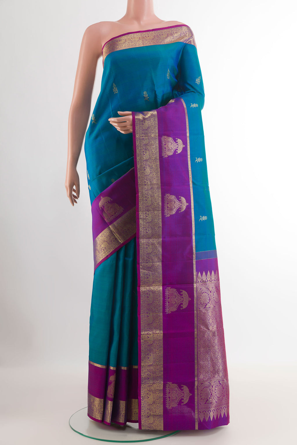 Peacock Blue Tussar Silk Saree with Zari Butta on the body and Zari Border.  displayed on a mannequin