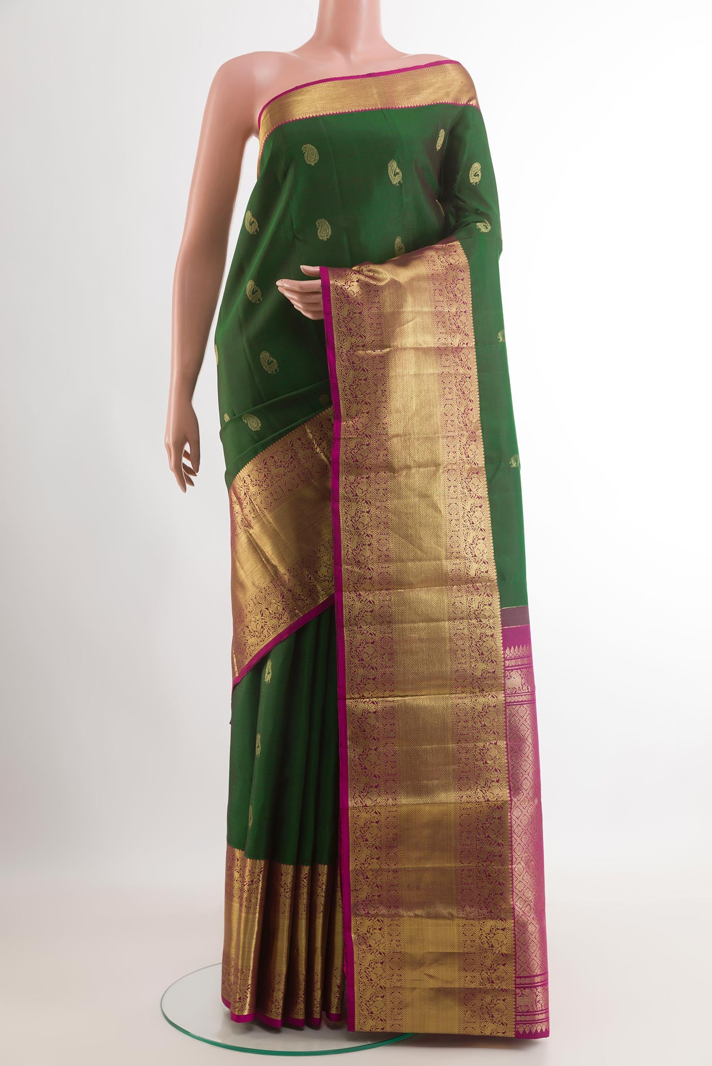 Green Kanchipuram Silk Saree with Zari Butta on the body and Zari Border.  displayed on a mannequin