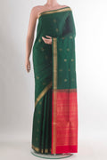 Pure Silk Bottle Green Soft Saree with Zari Butta on the body and Zari Border.  displayed on a mannequin