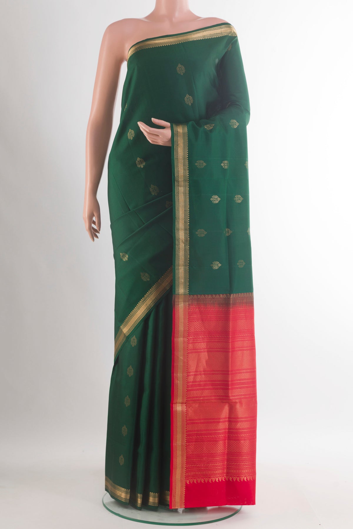 Pure Silk Bottle Green Soft Saree with Zari Butta on the body and Zari Border.  displayed on a mannequin