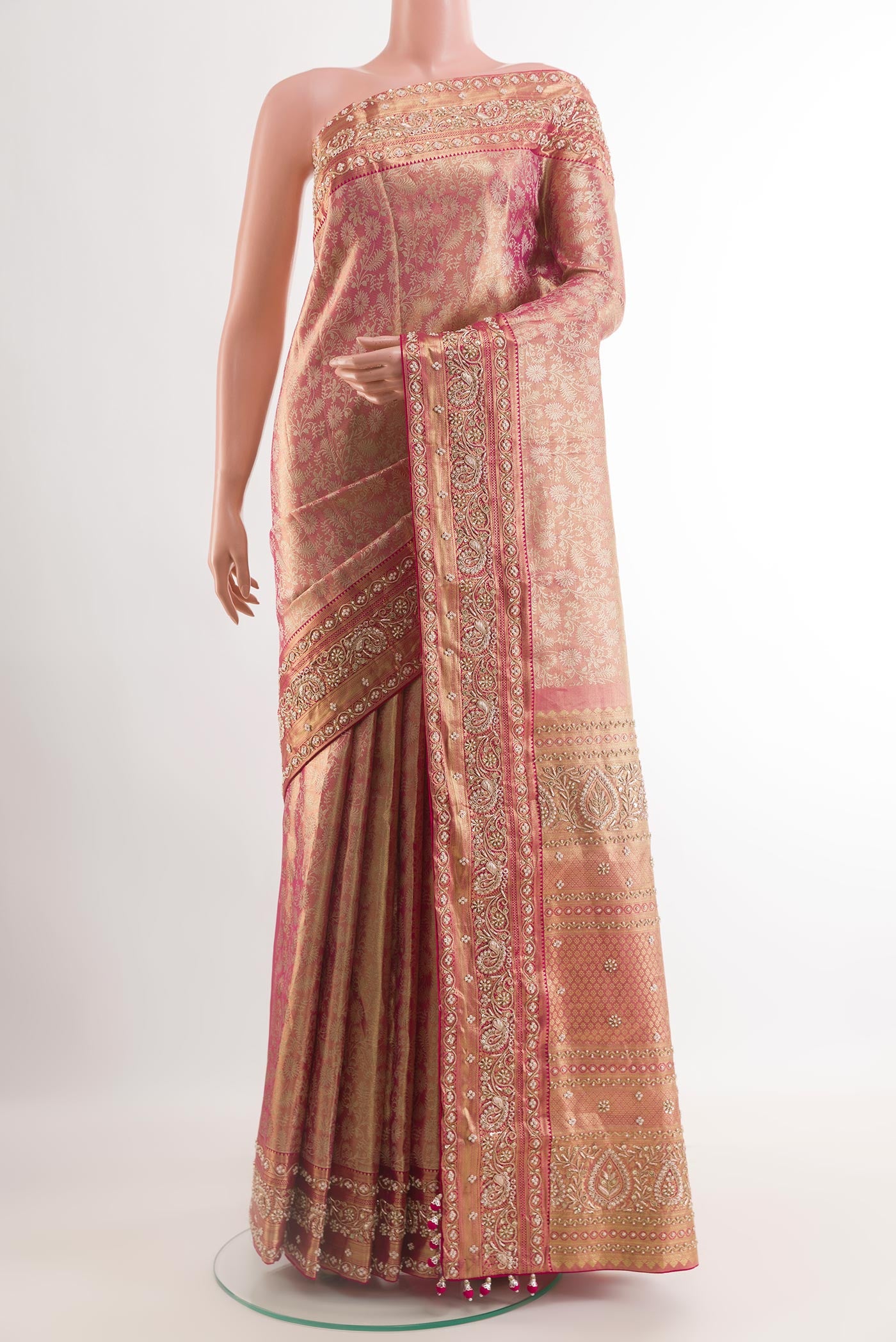 Rose pink Kanjivaram Tissue Silk Saree with Embroidery on the body and Zari Border.  displayed on a mannequin