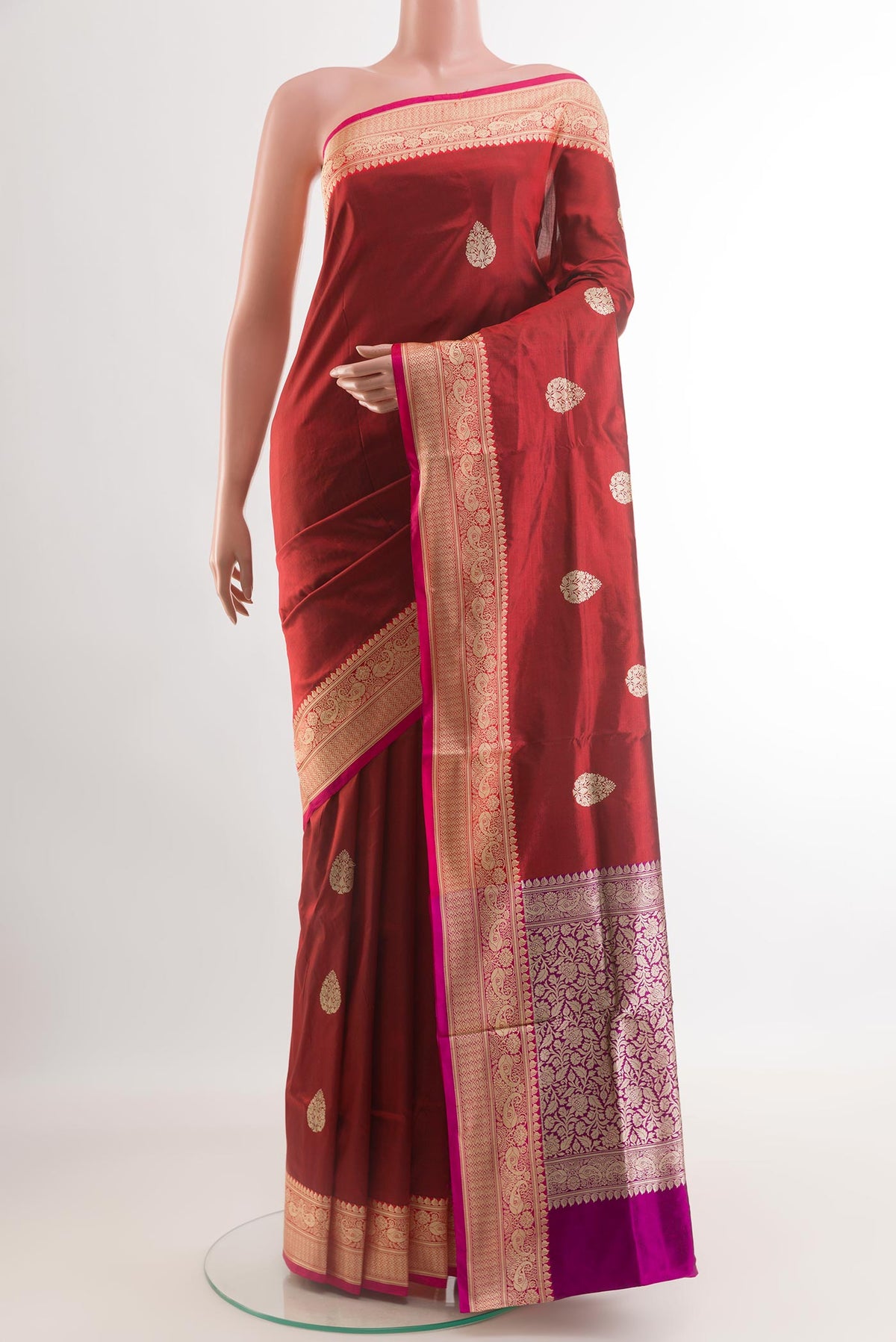 Maroon Banarasi Katan Silk Saree with Zari Butta on the body and Zari Border.  displayed on a mannequin
