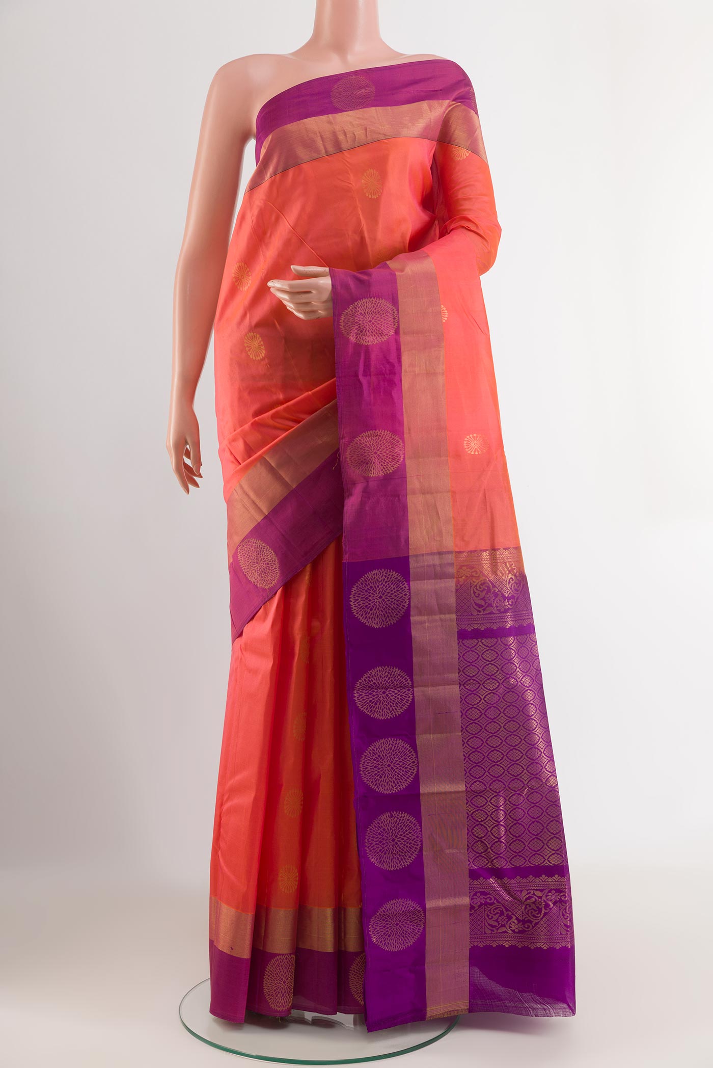Peach Kanjivaram Silk Saree with Zari Butta on the body and Zari Border.  displayed on a mannequin