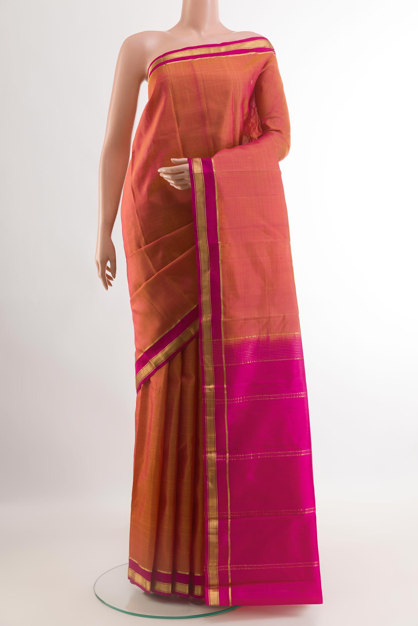Peach Kanchipuram Silk Saree with Zari Butta on the body and Zari Border.  displayed on a mannequin