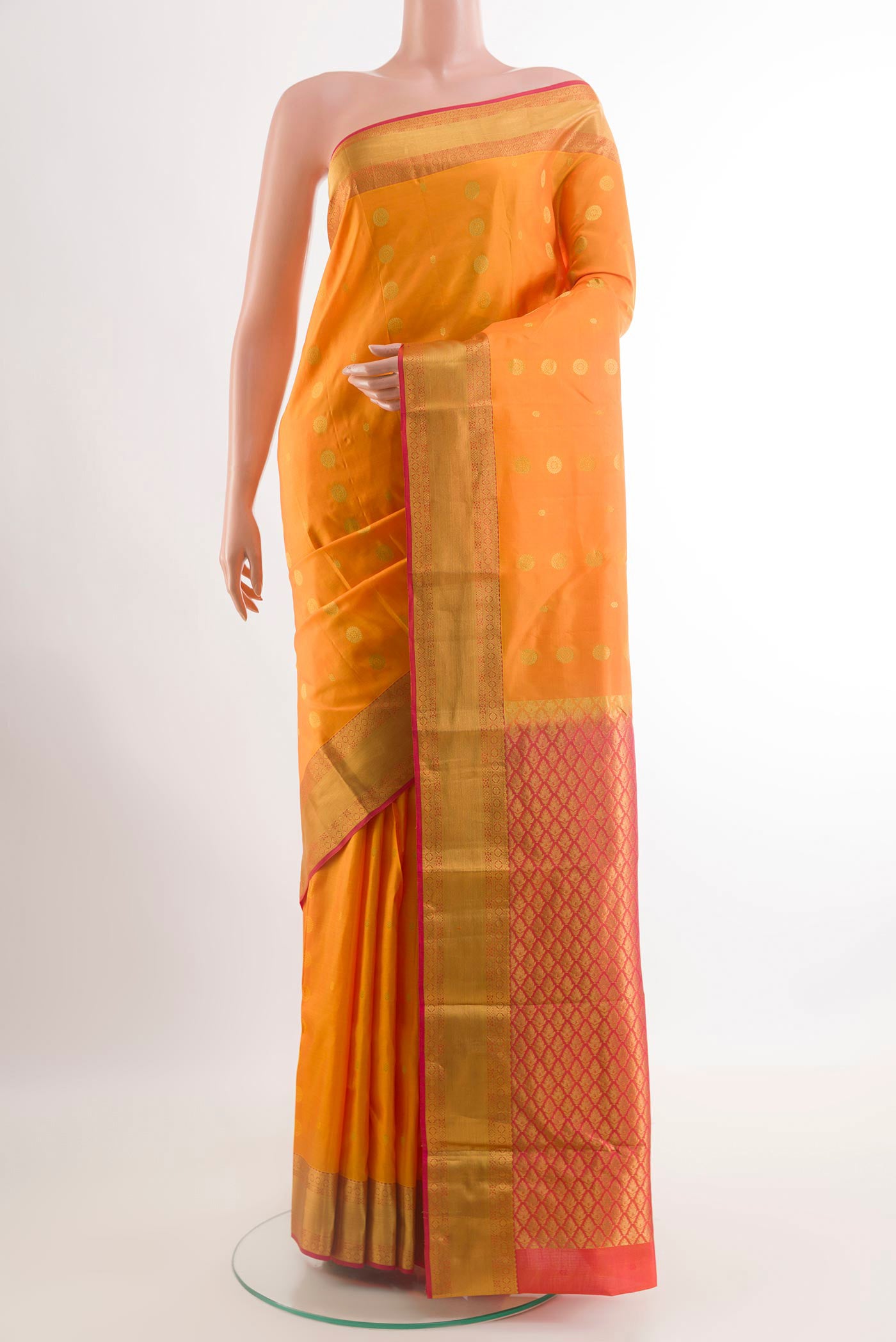 Mustard Kanjivaram Silk Saree with Zari Butta on the body and Zari Border.  displayed on a mannequin
