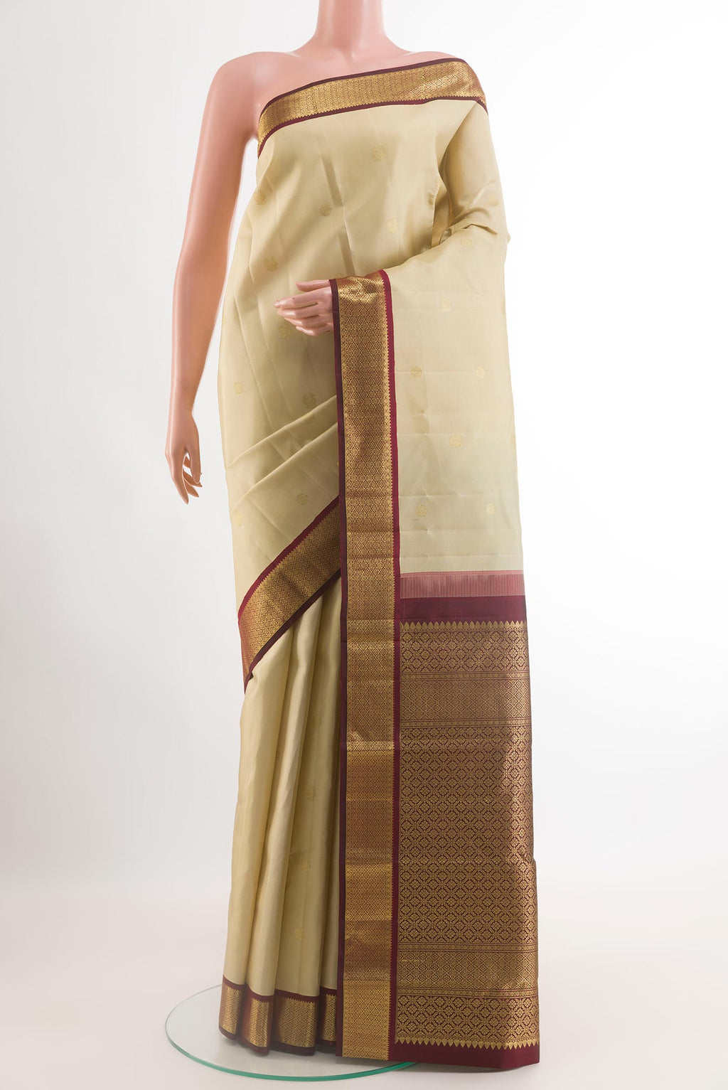Cream Kanjivaram Silk Saree with Zari Butta on the body and Zari Border.  displayed on a mannequin