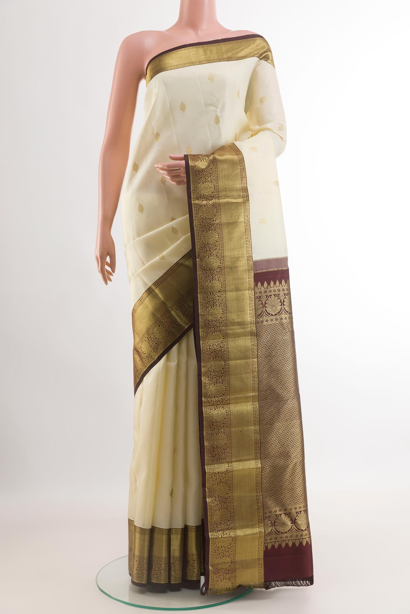 Off White Kanjivaram Silk Saree with Zari Butta on the body and Zari Border.  displayed on a mannequin