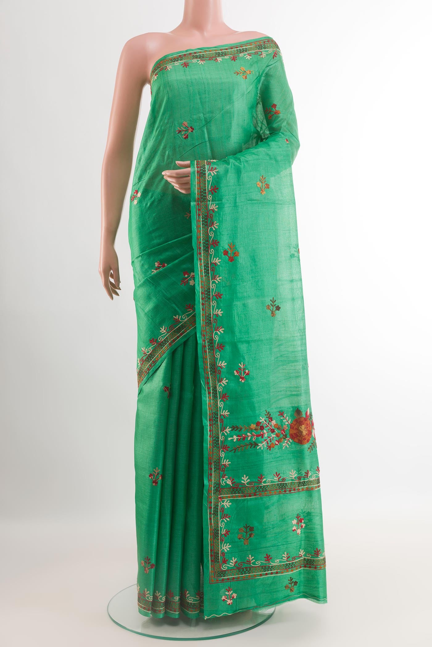 Green Tussar Saree with Embroidery on the body and Embroidery Border.  displayed on a mannequin