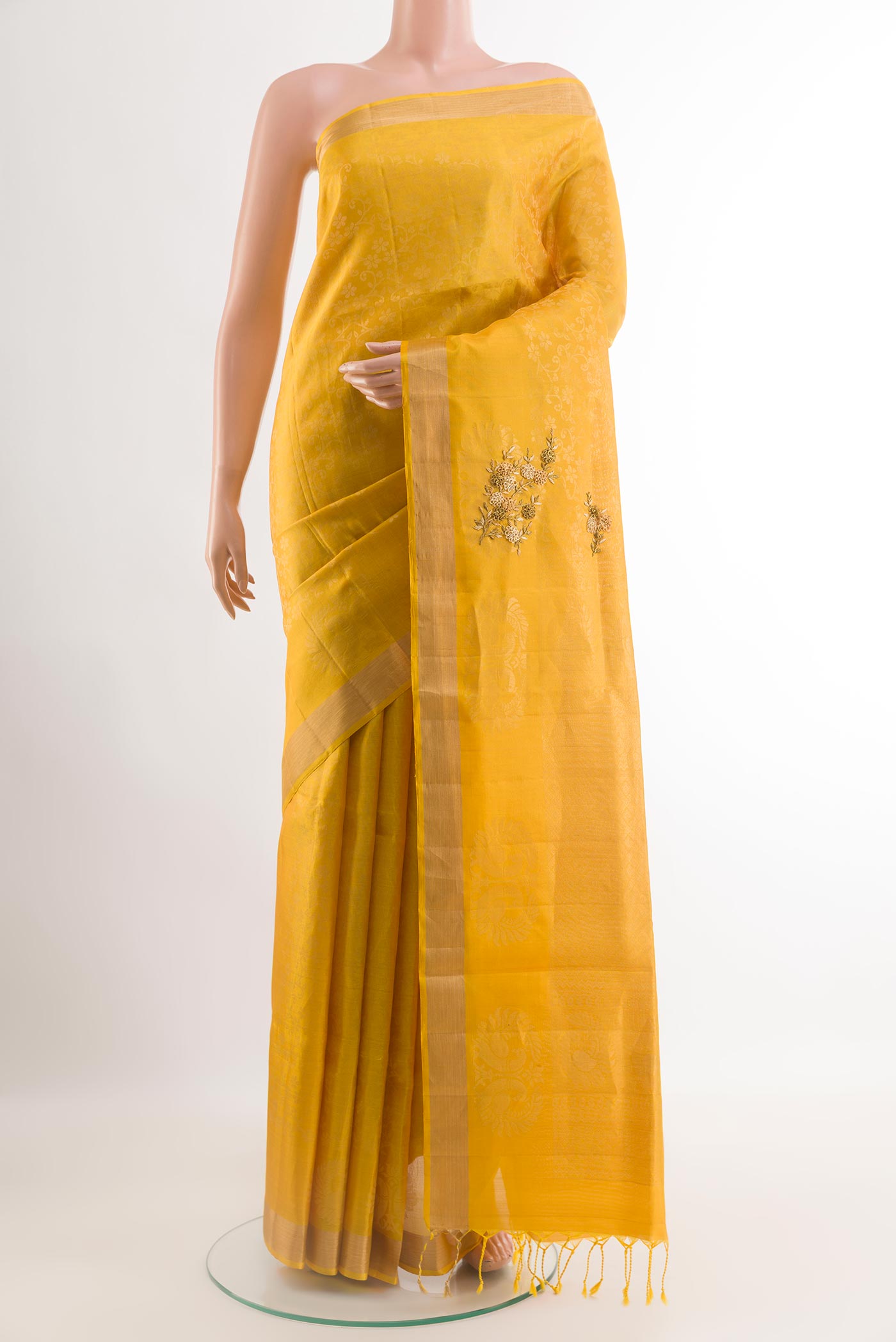 Yellow Soft Silk Saree with Embroidery on the body and Zari Border.  displayed on a mannequin