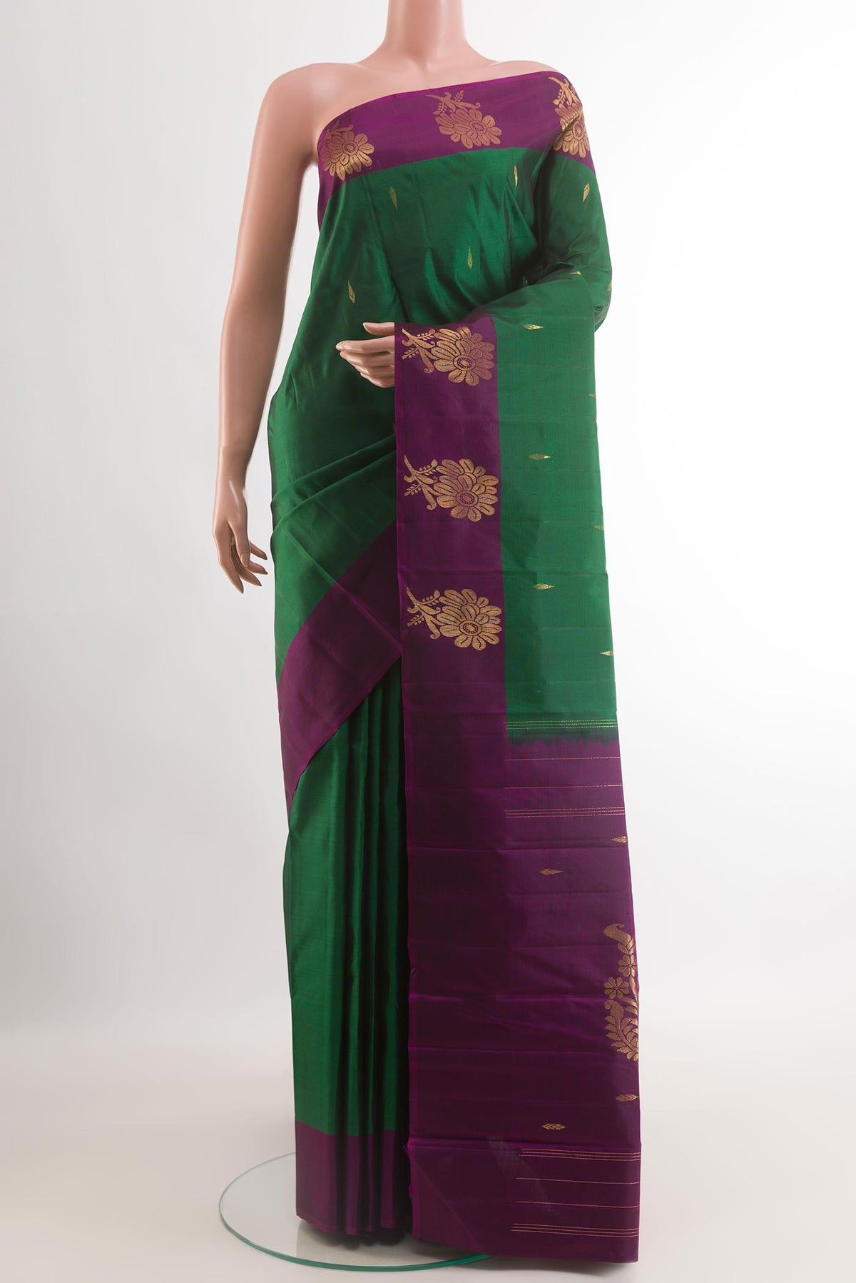 Green Kanchipuram Silk Saree with Zari Butta on the body and Zari Border.  displayed on a mannequin