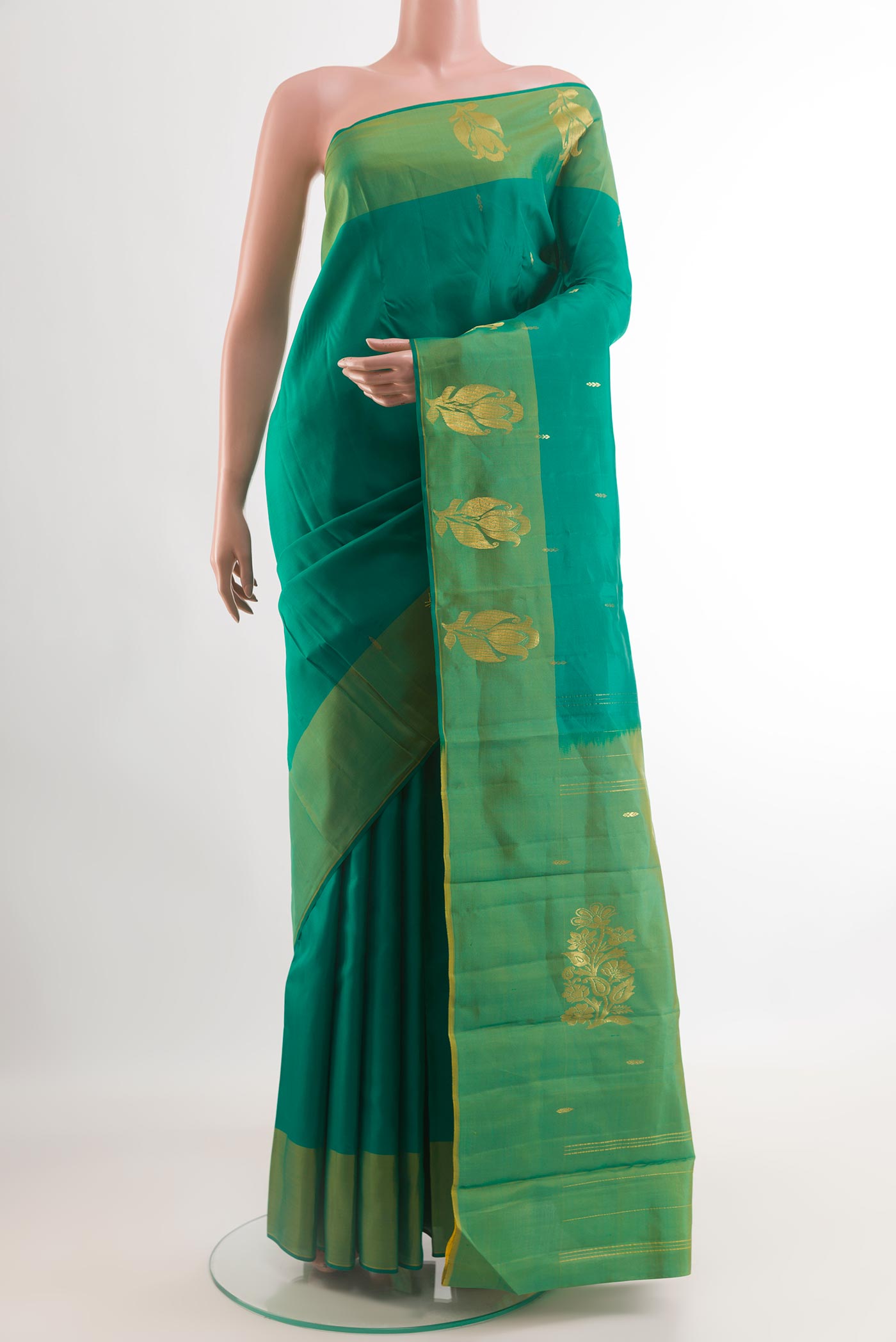 Green Kanchipuram Silk Saree with Zari Butta on the body and Zari Border.  displayed on a mannequin