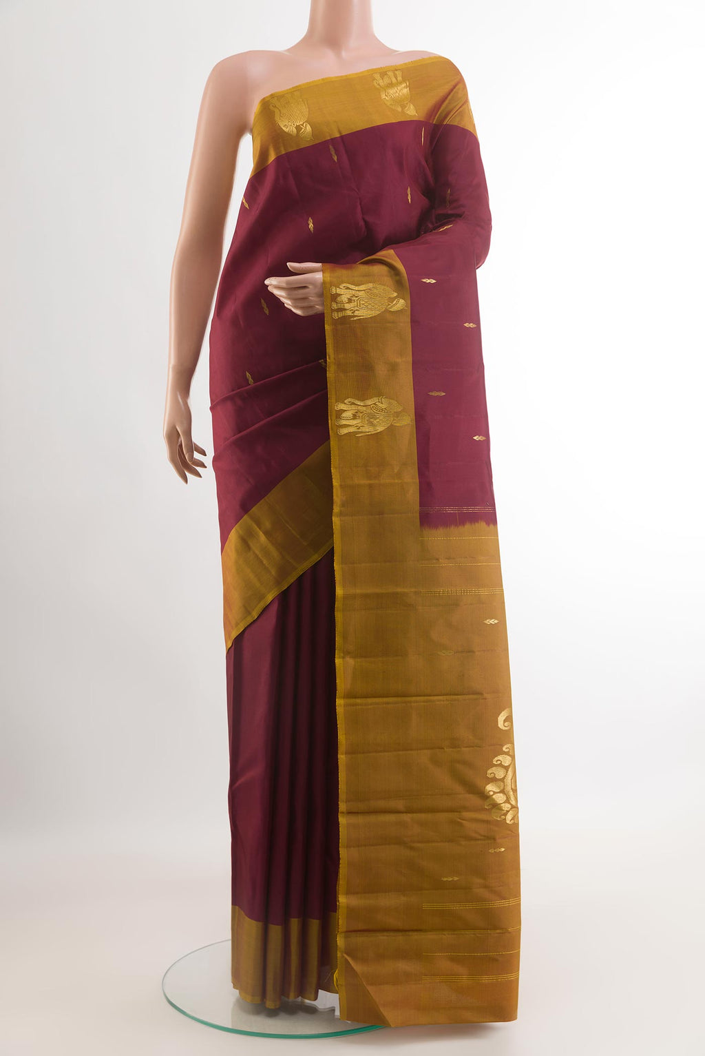 Maroon Kanchipuram Silk Saree with Zari Butta on the body and Zari Border.  displayed on a mannequin