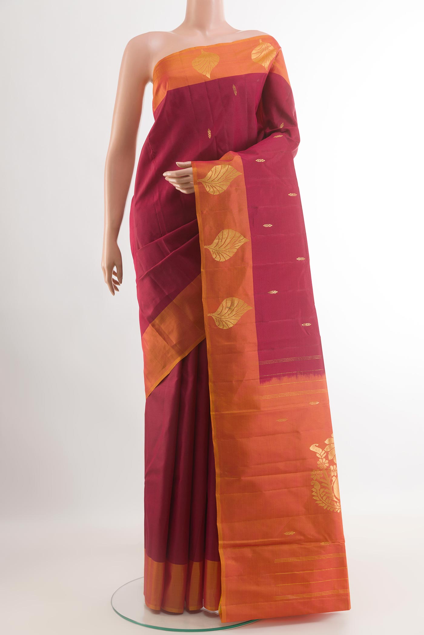 Maroon Kanchipuram Silk Saree with Zari Butta on the body and Zari Border.  displayed on a mannequin