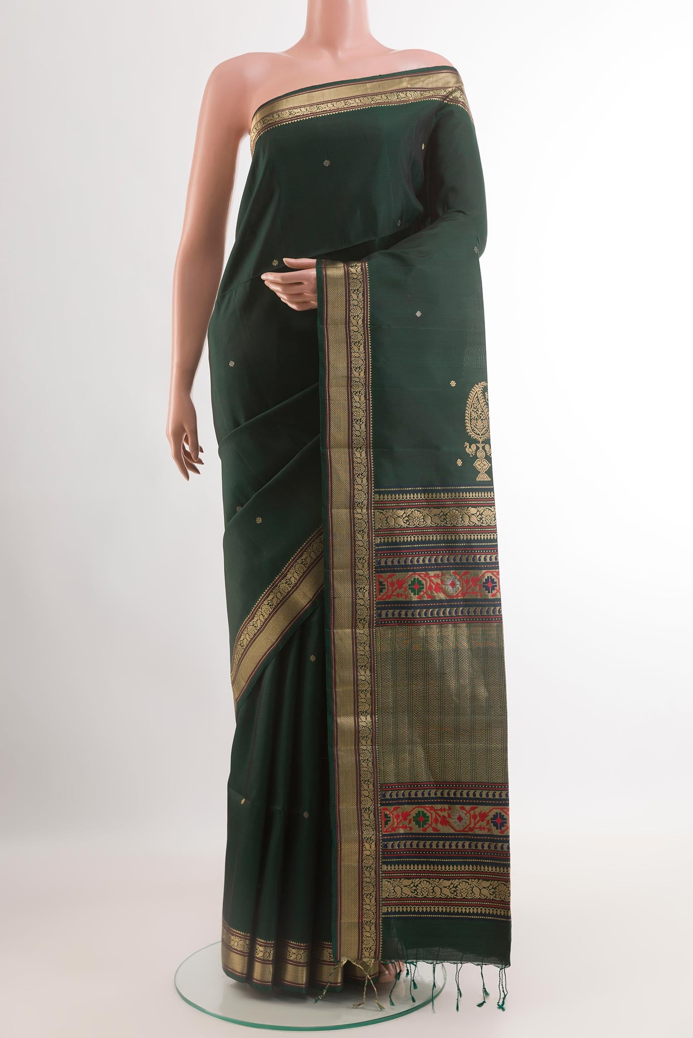 Bottle Green Soft Silk Saree with Zari Butta on the body and Zari Border.  displayed on a mannequin