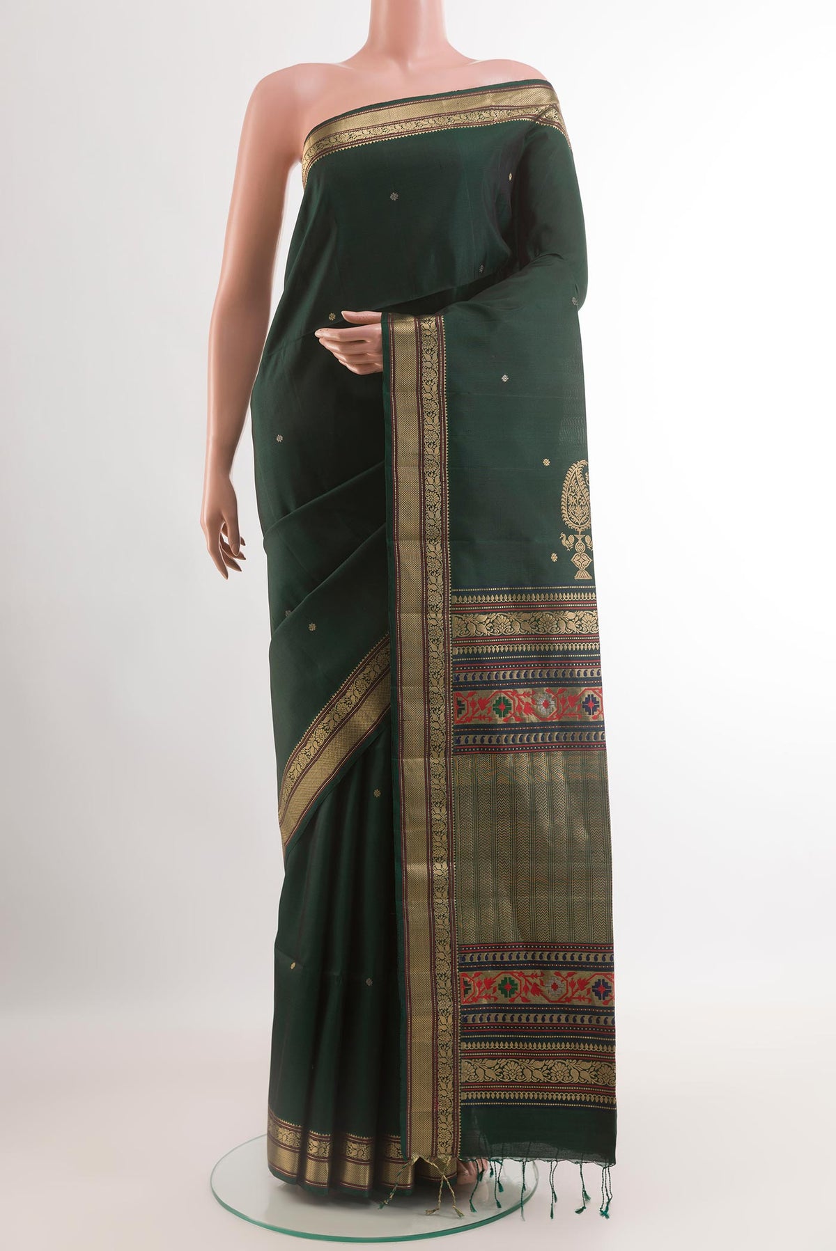 Bottle Green Soft Silk Saree with Zari Butta on the body and Zari Border.  displayed on a mannequin