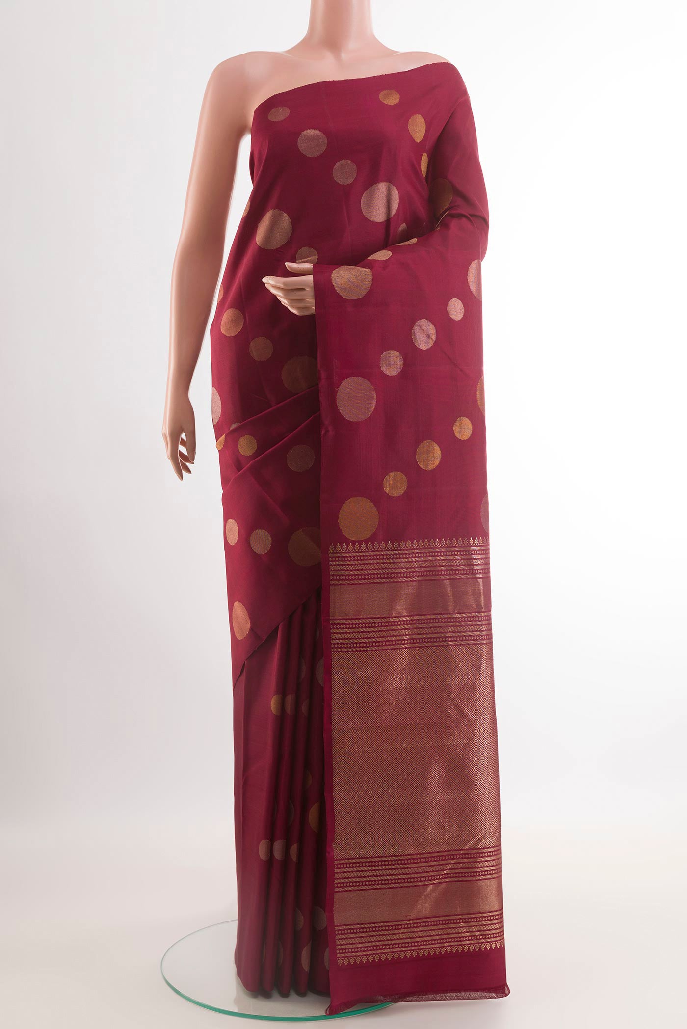 Maroon Kanjivaram Silk Saree with Zari Butta on the body and Zari Border.  displayed on a mannequin