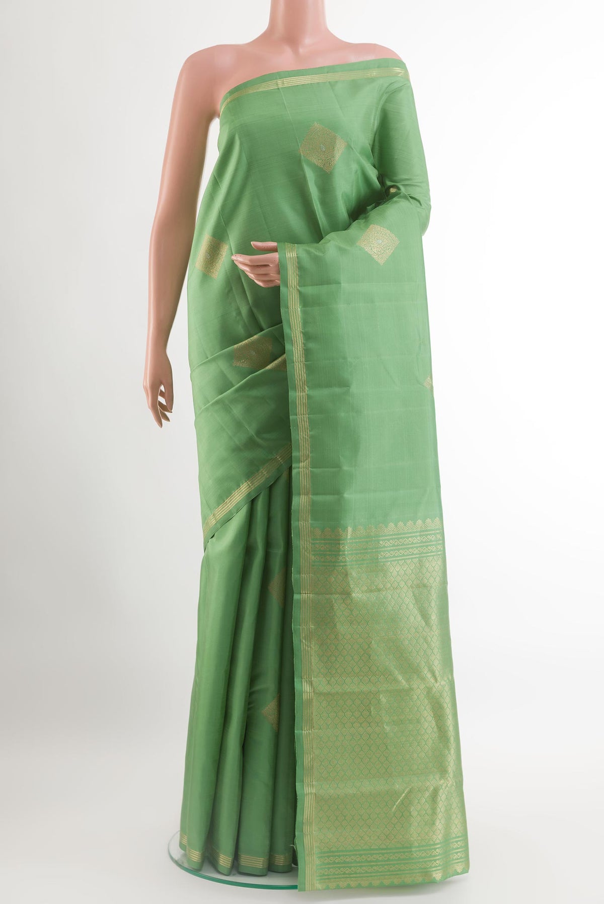 Light Green Kanchipuram Silk Saree with Zari Butta on the body and Zari Border.  displayed on a mannequin