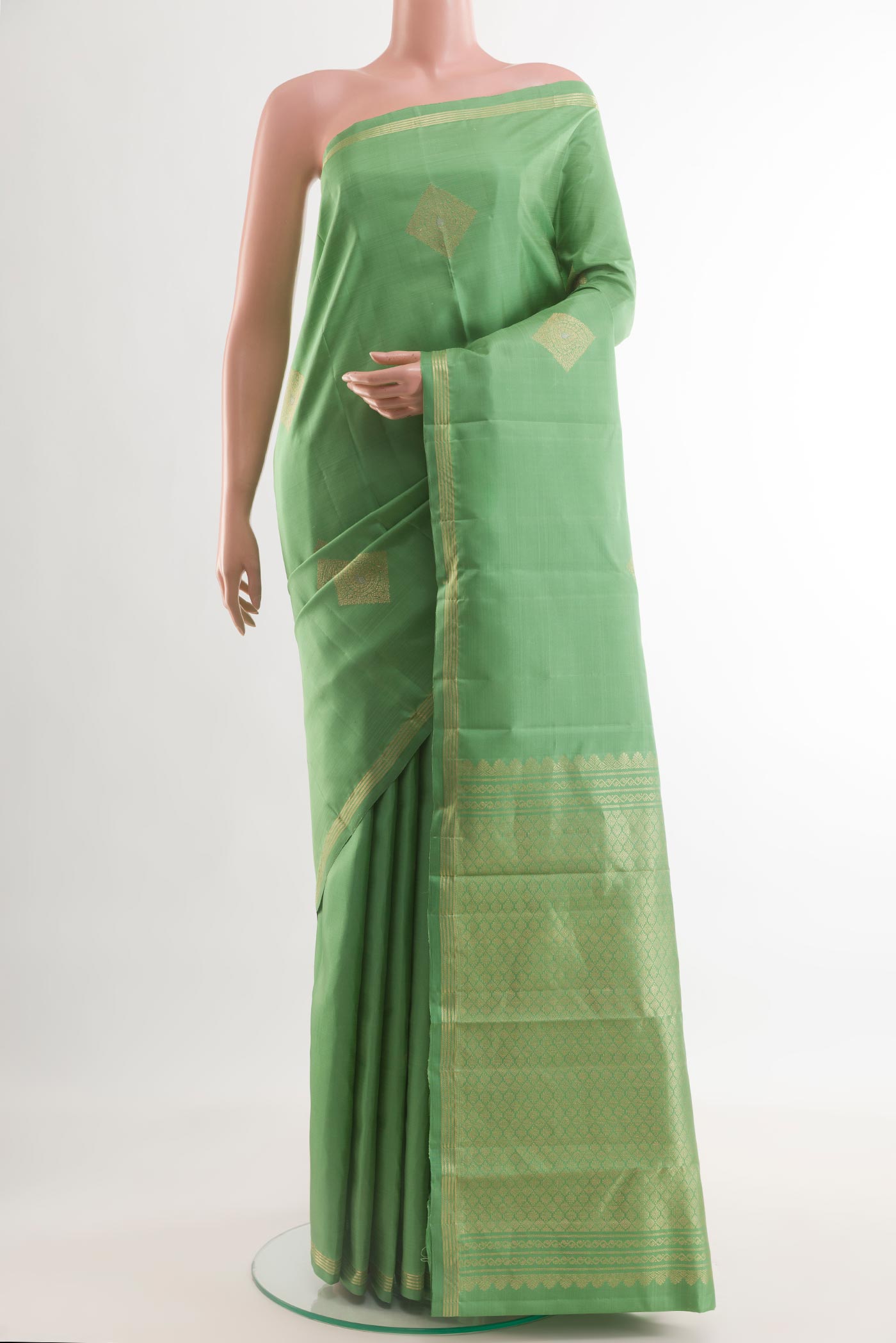 Pista Green Kanchipuram Silk Saree with Zari Butta on the body and Zari Border.  displayed on a mannequin