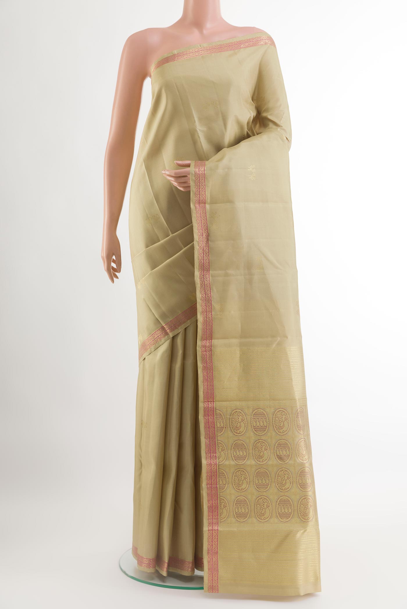 Beige Kanchipuram Silk Saree with Zari Butta on the body and Zari Border.  displayed on a mannequin
