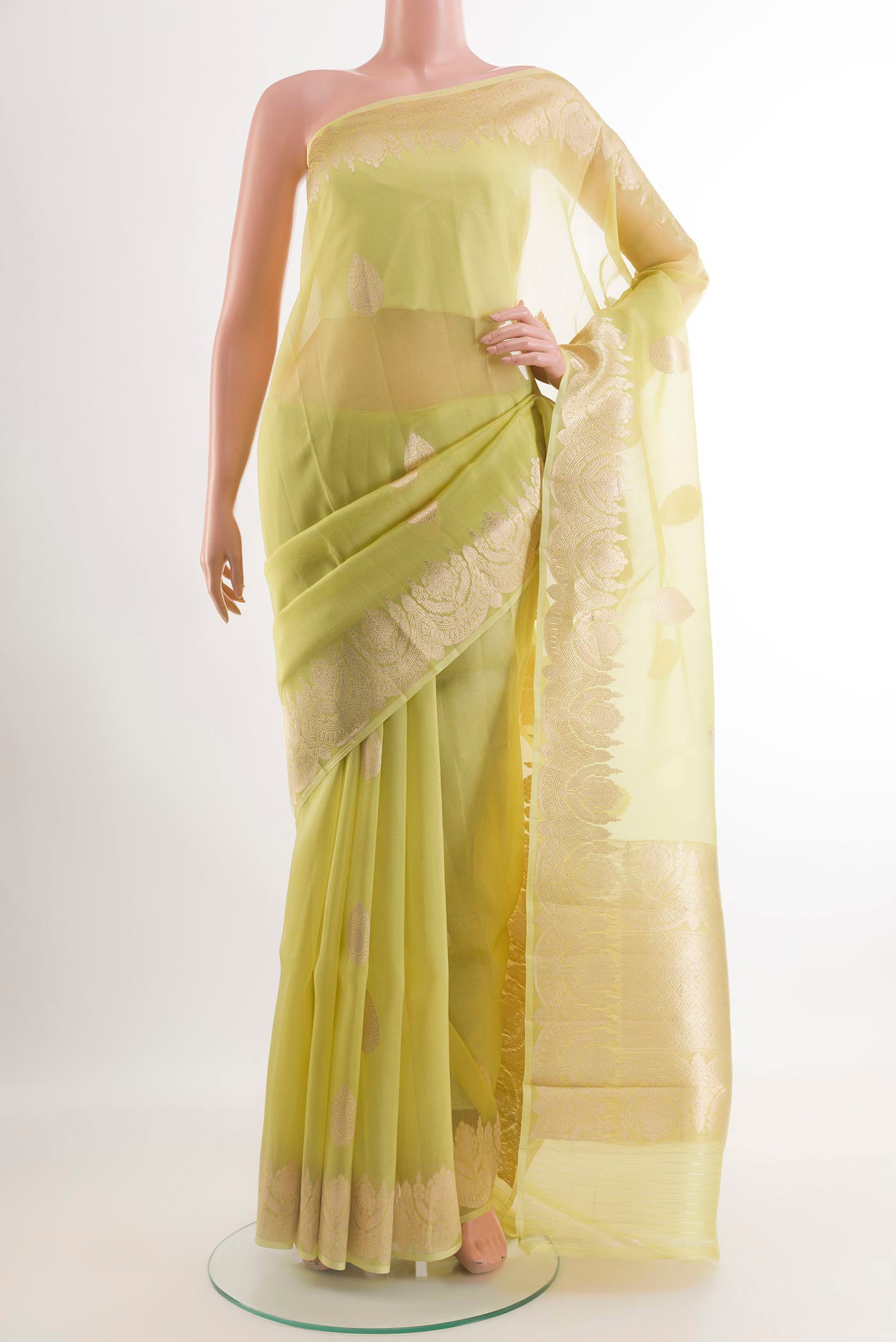 Green Organza Silk Saree with Zari Butta on the body and Zari Border.  displayed on a mannequin