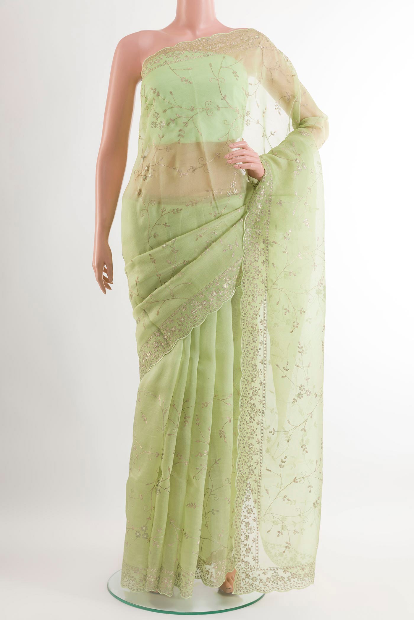 Green Organza Silk Saree with Zari Butta on the body and Embroidery Border.  displayed on a mannequin