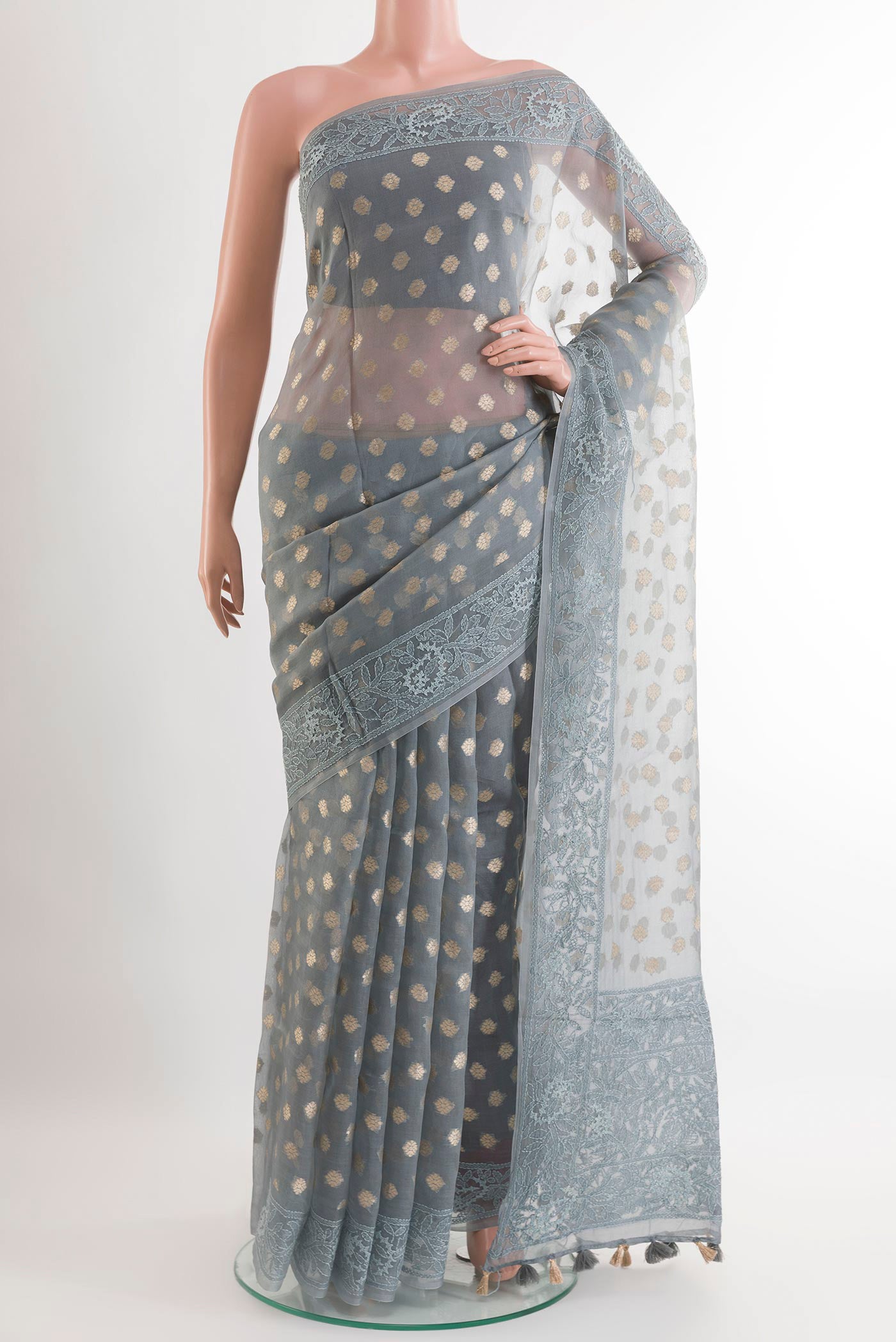 Grey Organza Silk Saree with Zari Butta on the body and Embroidery Border.  displayed on a mannequin