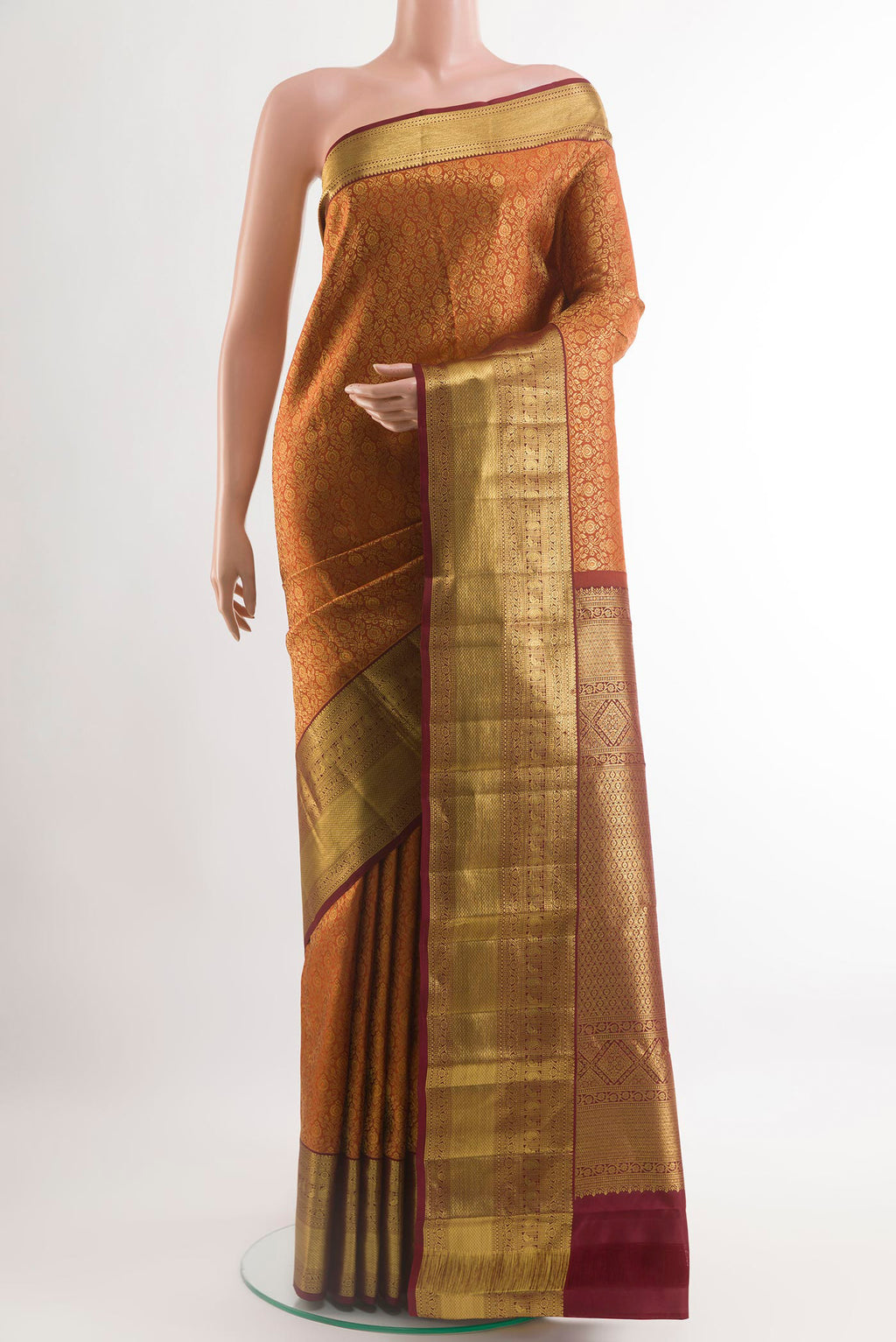 Mustard Kanchipuram Silk Saree with Zari Brocade on the body and Zari Border.  displayed on a mannequin