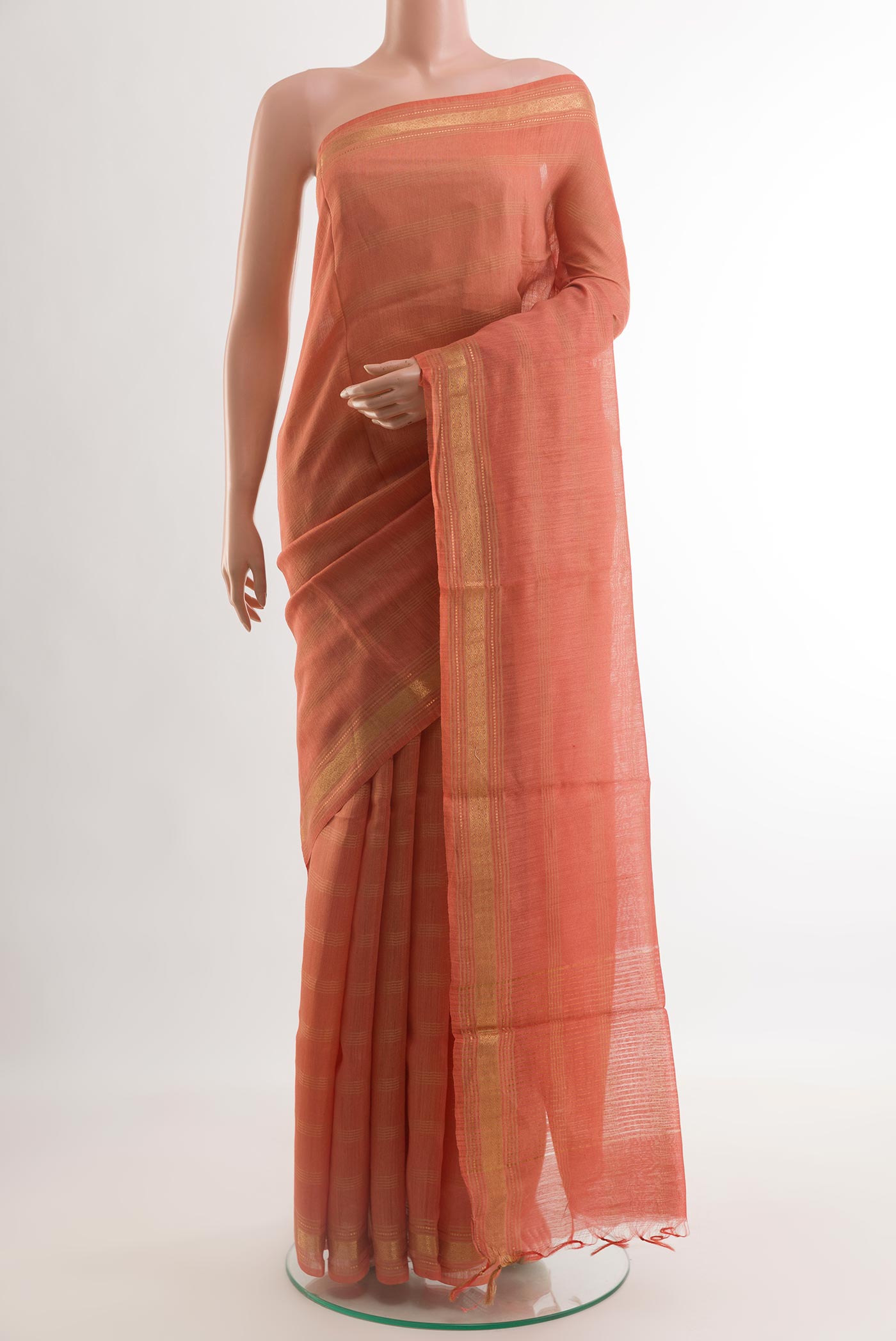 Peach Tussar Saree with Checked design on the body and Zari Border.  displayed on a mannequin